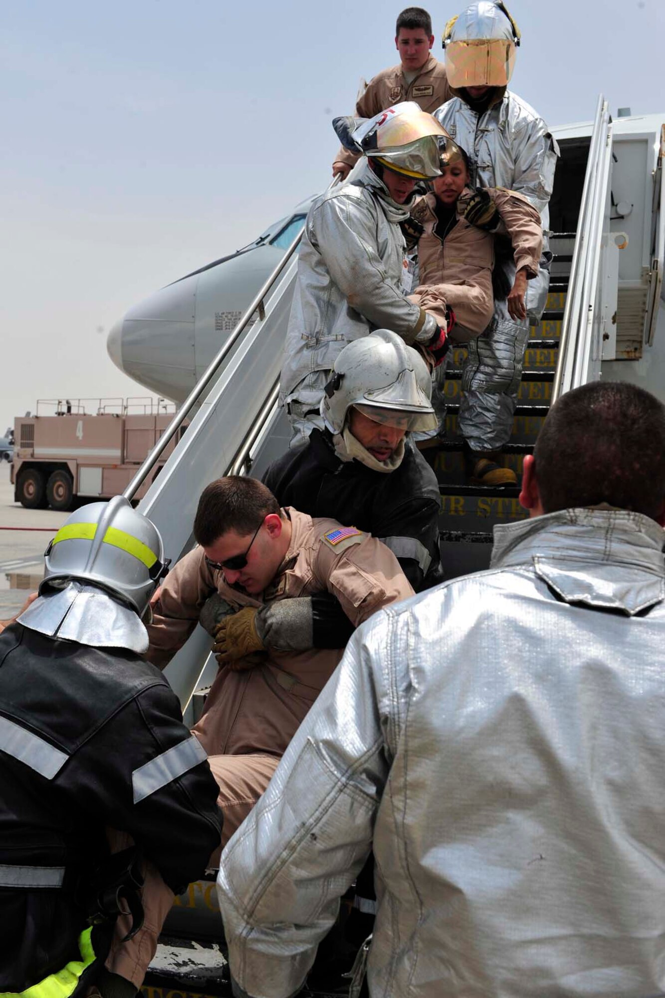 380th Expeditionary Civil Engineer Squadron firemen and French air force firefighters remove casualties from an aircraft during a combined training scenario on the flightline. The scenario simulated an auxiliary power unit ,or APU, exploding causing a ground fire with nine casualties. (U.S. Air Force photo/Staff Sgt. Patrick Mitchell)
