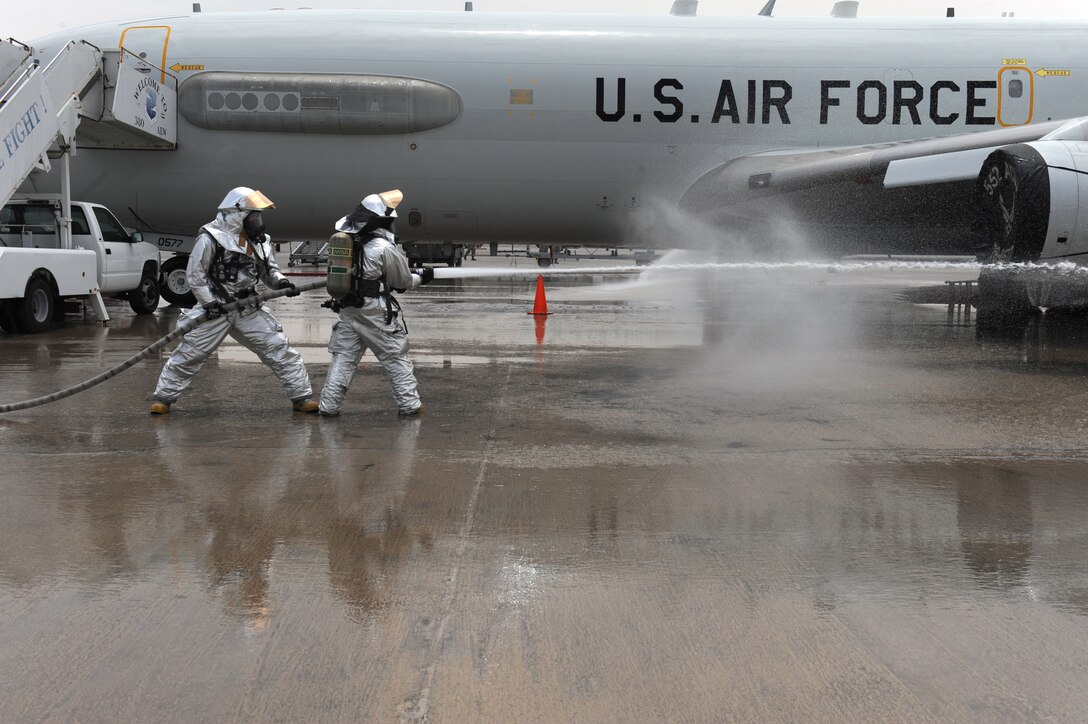 380th Expeditionary Civil Engineer Squadron firefighters spray water toward cones that are simulating fire during an exercise with the French and host nation fire departments, July 26, 2011, at the 380th Air Expeditionary Wing in Southwest Asia.The scenario simulated an auxiliary power unit, or APU, exploding causing a ground fire with nine casualties. (U.S. Air Force photo/Master Sgt. Chance Babin)