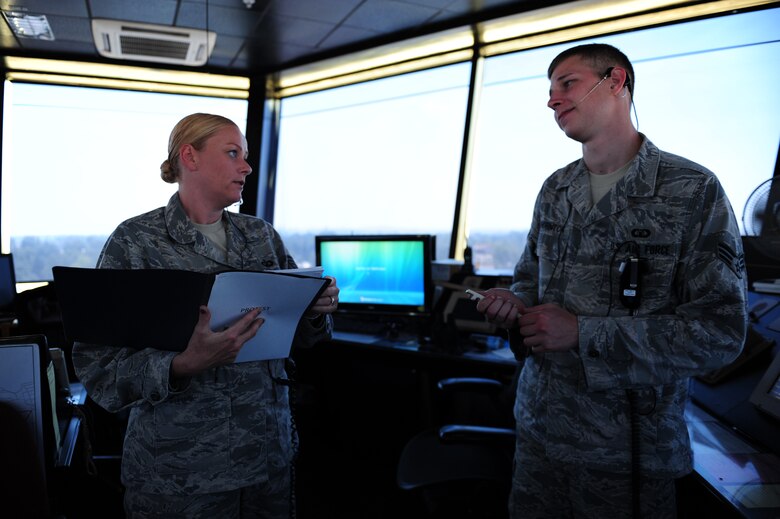 Tech. Sgt. Jennifer Rowles, 39th Operations Squadron tower watch supervisor, and Senior Airman Matthew Thornton, 39th OS air traffic control journeyman, discuss air traffic control procedures July 27, 2011, at Incirlik Air Base, Turkey. Air traffic controllers must take a monthly proficiency test to ensure they are knowledgeable about all rules and regulations. (U.S. Air Force photo by Senior Airman Anthony Sanchelli/Released)