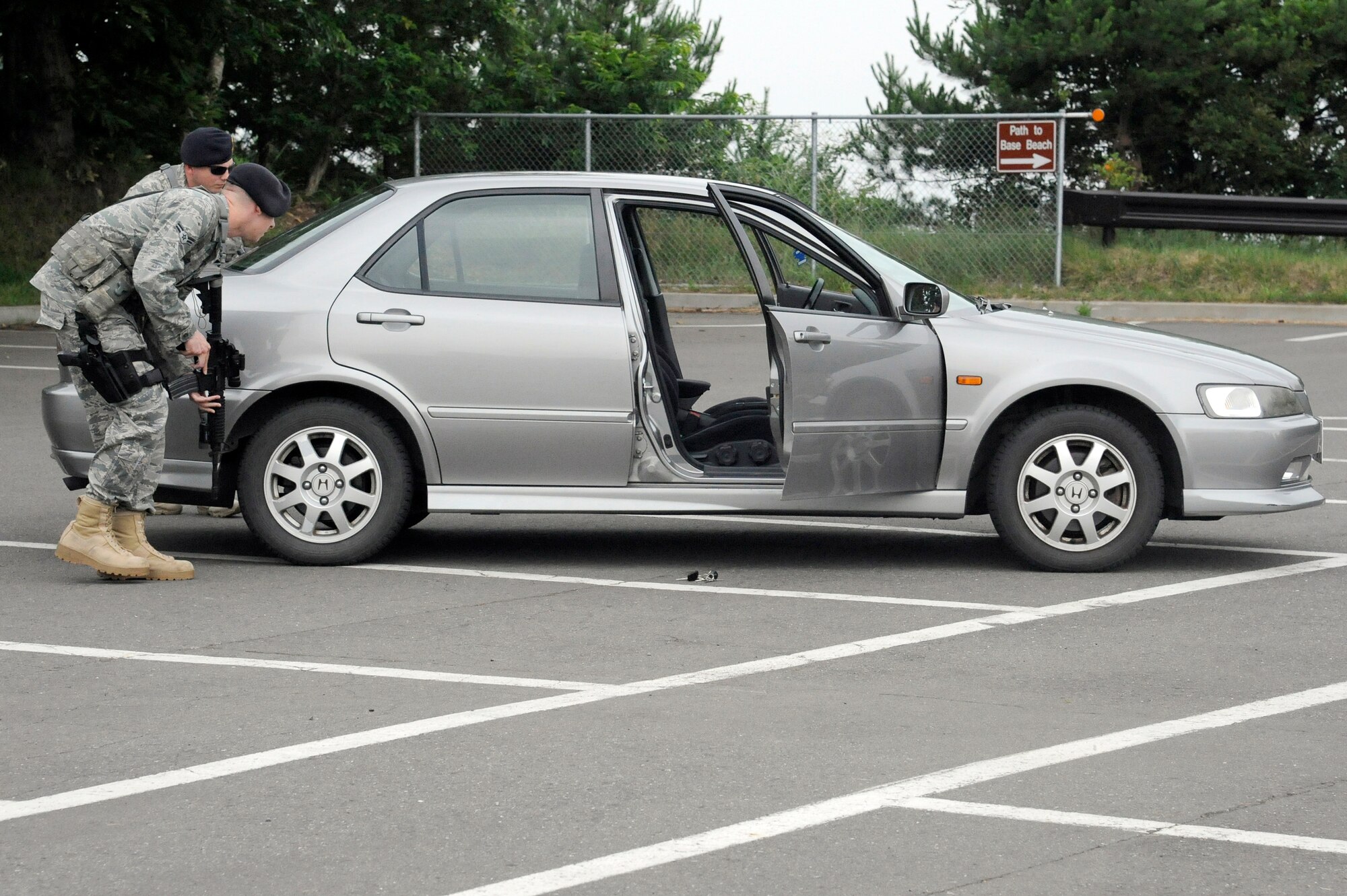 MISAWA AIR BASE, Japan -- Airmen with the 35th Security Forces Squadron tactically approach the suspects getaway car used in a simulated robbery at Cafe Aomori during a training exercise July 28. The exercise gave law enforcement Airmen an opportunity to practice maintaining security around the base. (U.S. Air Force photo/Staff Sgt. Marie Brown)