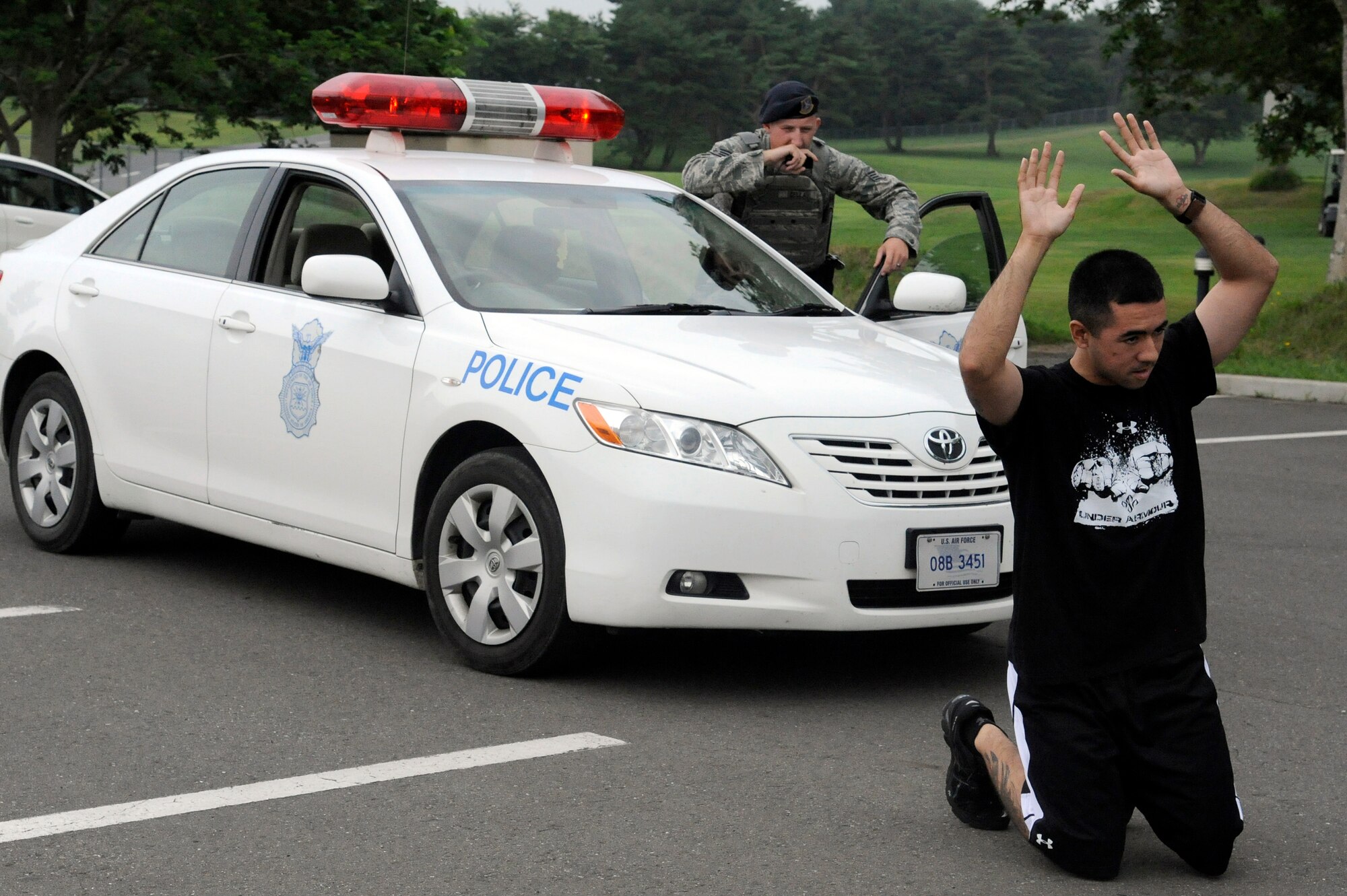 MISAWA AIR BASE Japan -- Staff Sgt. Matthew Cella, back, 35th Security Forces Squadron, gives verbal commands to a suspect during a robbery training exercise scenario July 28. The exercise allowed Airmen to demonstrate their ability to regain control of a robbery scenario. (U.S. Air Force photo/Staff Sgt. Marie Brown)