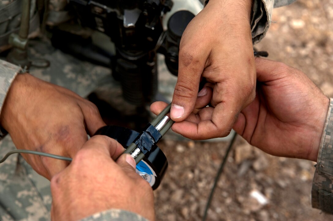 U.S. soldiers tape a blasting cap to a detonation cord during Talisman Sabre 2011 at the Shoalwater Bay Training Area in Queensland, Australia, July 15, 2011. The soldiers are assigned to the  2nd Infantry Division's 38th Engineers Company, 4th Stryker Brigade Combat Team.