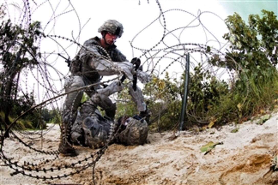 A combat engineer working as part of a team cuts through a wire obstacle during a training exercise at Fort Bragg, N.C., on July 21, 2011.  The engineers are assigned to the 82nd Airborne Division's 1st Brigade Combat Team.  