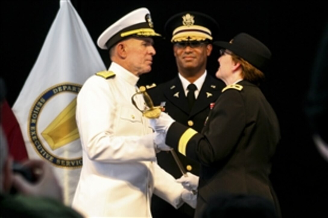 Army Maj. Gen. Carla Hawley-Bowland, right, commander of Walter Reed Army Medical Center in Washington, D.C., passes the Walter Reed sword to the National Naval Medical Center's commanding officer, Navy Rear Adm. Matthew L. Nathan, during a July 27, 2011, ceremony marking the casing of Walter Reed's colors. The two hospitals are consolidating in Bethesda, Md., to form the Walter Reed National Military Medical Center.  