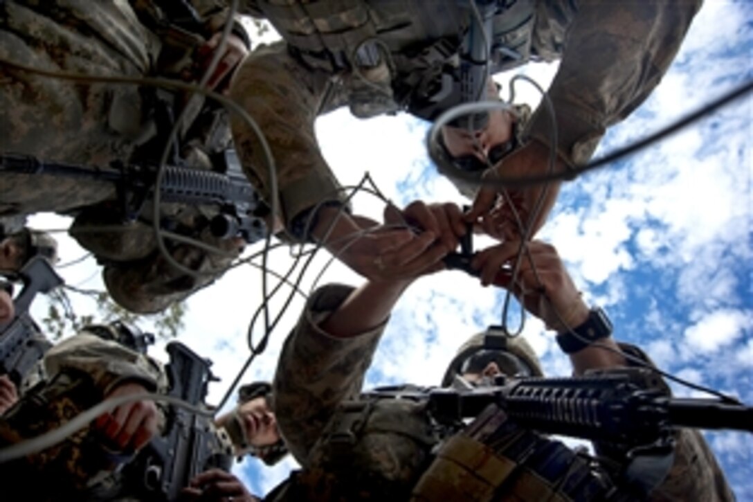 U.S. Army soldiers tape a blasting cap to a detonation cord during Talisman Sabre 2011 at the Shoalwater Bay Training Area in Queensland, Australia, July 15, 2011. The soldiers are assigned to the 2nd Infantry Division's 38th Engineers Company, 4th Stryker Brigade Combat Team. Talisman Sabre is a bilateral exercise to train U.S. and Australian forces in combined operations to improve combat readiness and interoperability.