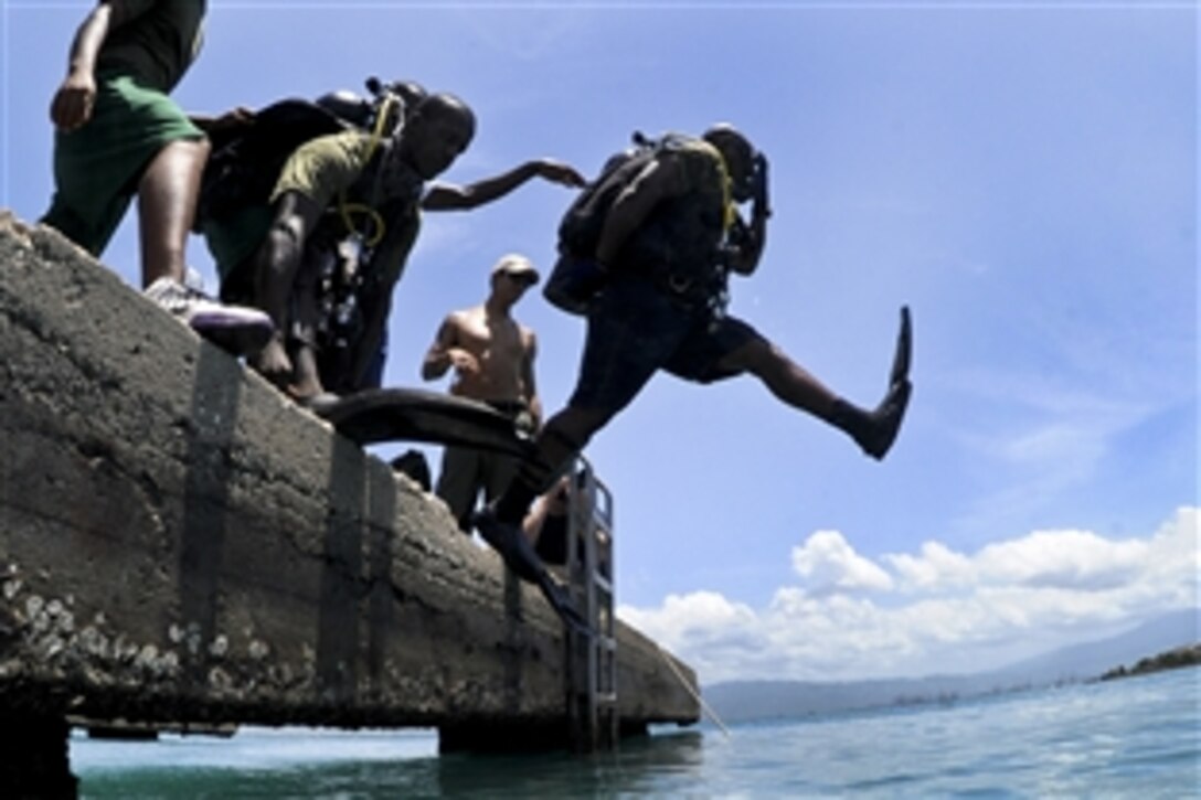 A Jamaican Coast Guard diver enters the water using the step-entry method during diving operations with the U.S. Navy Mobile Diving and Salvage Unit 2 in Jamaica, July 26, 2011. The  unit is participating in Navy Diver-Southern Partnership Station, a multinational partnership engagement to increase interoperability and partner capability through diving operations.