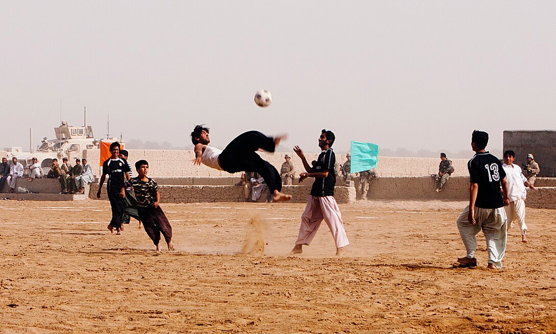 Members of the Safar soccer team compete after the opening of a sports complex here, July 28. The complex has a regulation-sized soccer field and two volleyball courts. Marines of Charlie Company, 1st Battalion 3rd, Marine Regiment partnered with local Afghan National Army soldiers to provide security during the opening.