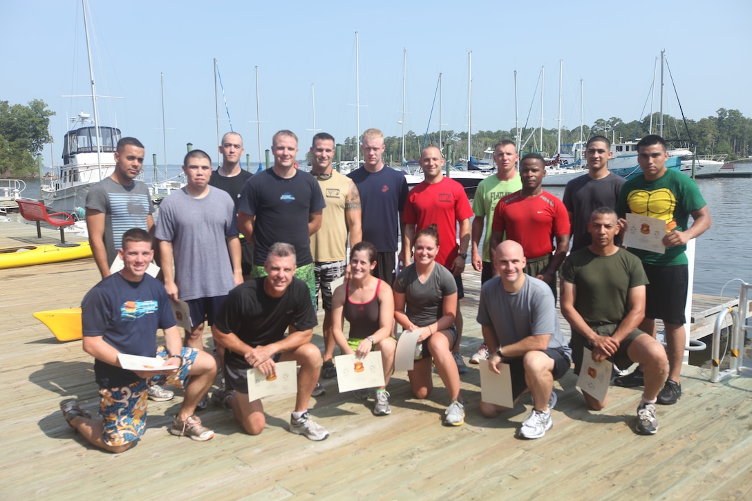 Marines and sailors take a moment to pose for a photo after completing a triathlon, which was the second of a series of events i nthe Headquarters and Support Battalion, Marine Corps Base Camp Lejeune, Commander's Cup Challenge, July 29.