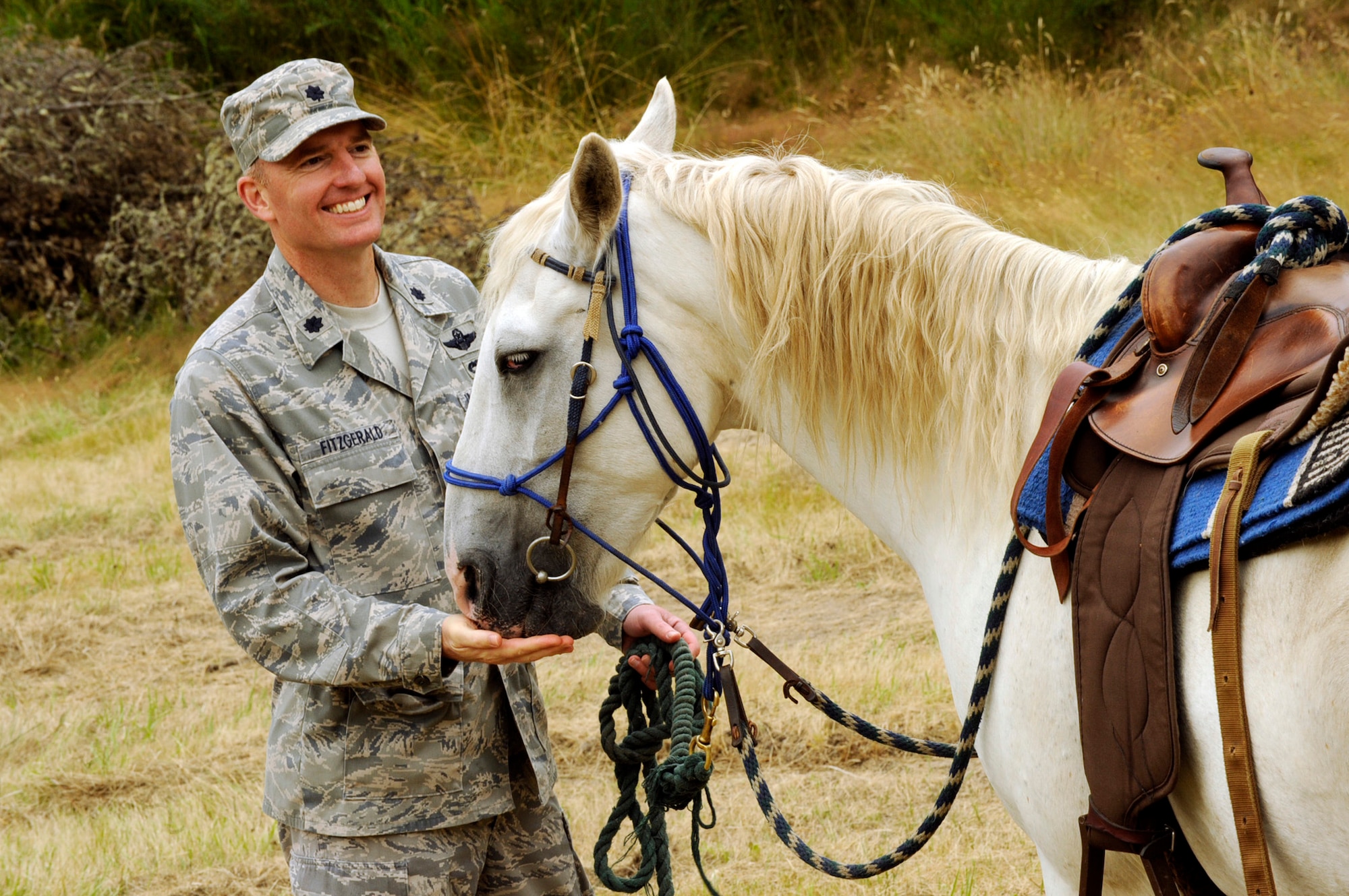 Oregon Air National Guard Lt. Col. Paul Fitzgerald gives a quick snack to Smokey, one of the horses at Camp Rosenbaum as part of the V.I.G. Day (Very Important Guest) tour of events on July 27, 2011. Camp Rosenbaum is a youth citizenship camp held each year at Camp Rilea, Ore., and is joint partnership between the Oregon Air National Guard, Portland Police Department of other area first responders.  (U.S. Air Force photograph by Tech. Sgt. John Hughel, 142nd Fighter Wing Public Affairs) (Released)