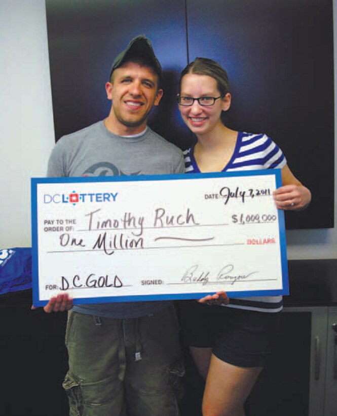Staff Sgt. Timothy Ruch, 11th Wing Command Post Status of Resources and Training System manager, and Senior Airman Emily Ruch, 11th WG/CP senior controller, accept a check for $1 million after winning on a $20 scratch ticket during a baseball game July 5 at Nationals Park.  (Courtesy Photo)