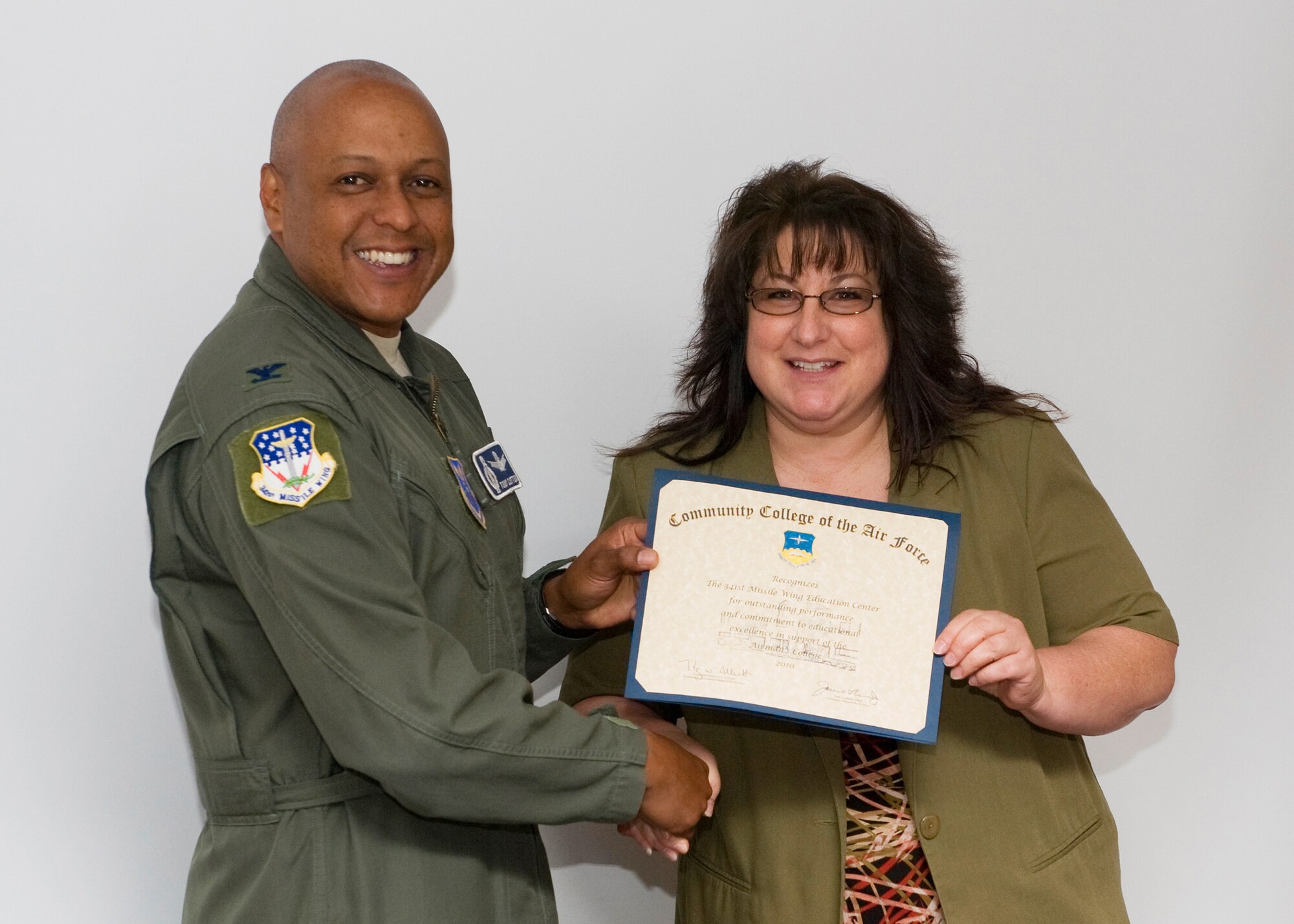Col. Anthony Cotton, 341st Missile Wing commander, presents a certificate of appreciation for outstanding achievement to Lanette Hetrick, 341st Force Support Squadron education services specialist; representing the 341st Missile Wing Education Services Center.  Malmstrom's Education Center's commitment to developing Air Force human resources led to the award of 140 Community College of the Air Force associate in applied science degrees during 2010.  (U.S. Air Force photo/Beau Wade)