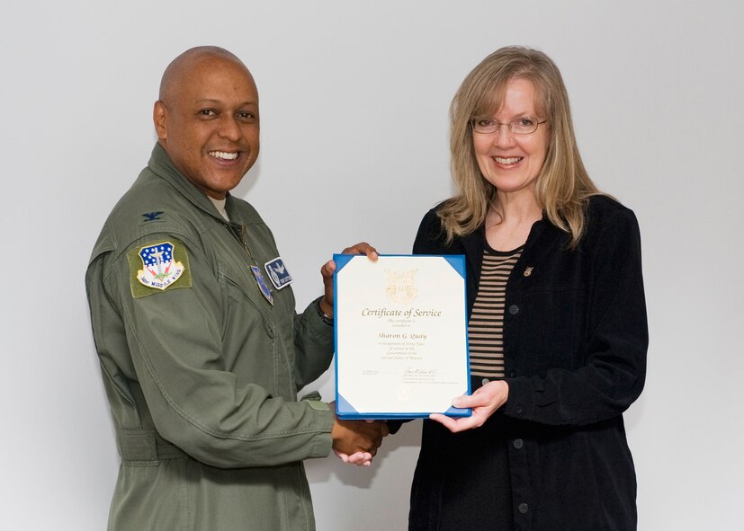 Col. Anthony Cotton, 341st Missile Wing commander, presents Sharon Quay, 341st Medical Group commander support staff member, with a certificate of service July 13.  The certificate recognizes Quay's 40 years of service in the United States government.  (U.S. Air Force photo/Beau Wade)