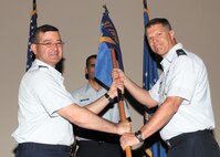 Col. Eric Axelbank, 37th Training Wing commander, presents the unit guidon to Col. Marc F. Stratton, new IAAFA commander, symbolizing his taking charge of the organization. (U.S. Air Force photo/Robbin Cresswell)