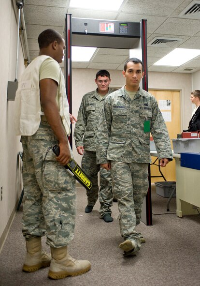 Simulated deployers walk through a metal detector during a mobility exercise on Barksdale Air Force Base, La., July 28. The exercise was the first one of its kind at Barksdale to process simulated deployers alongside real world deployers. (U.S. Air Force photo/Senior Airman Chad Warren) (RELEASED)