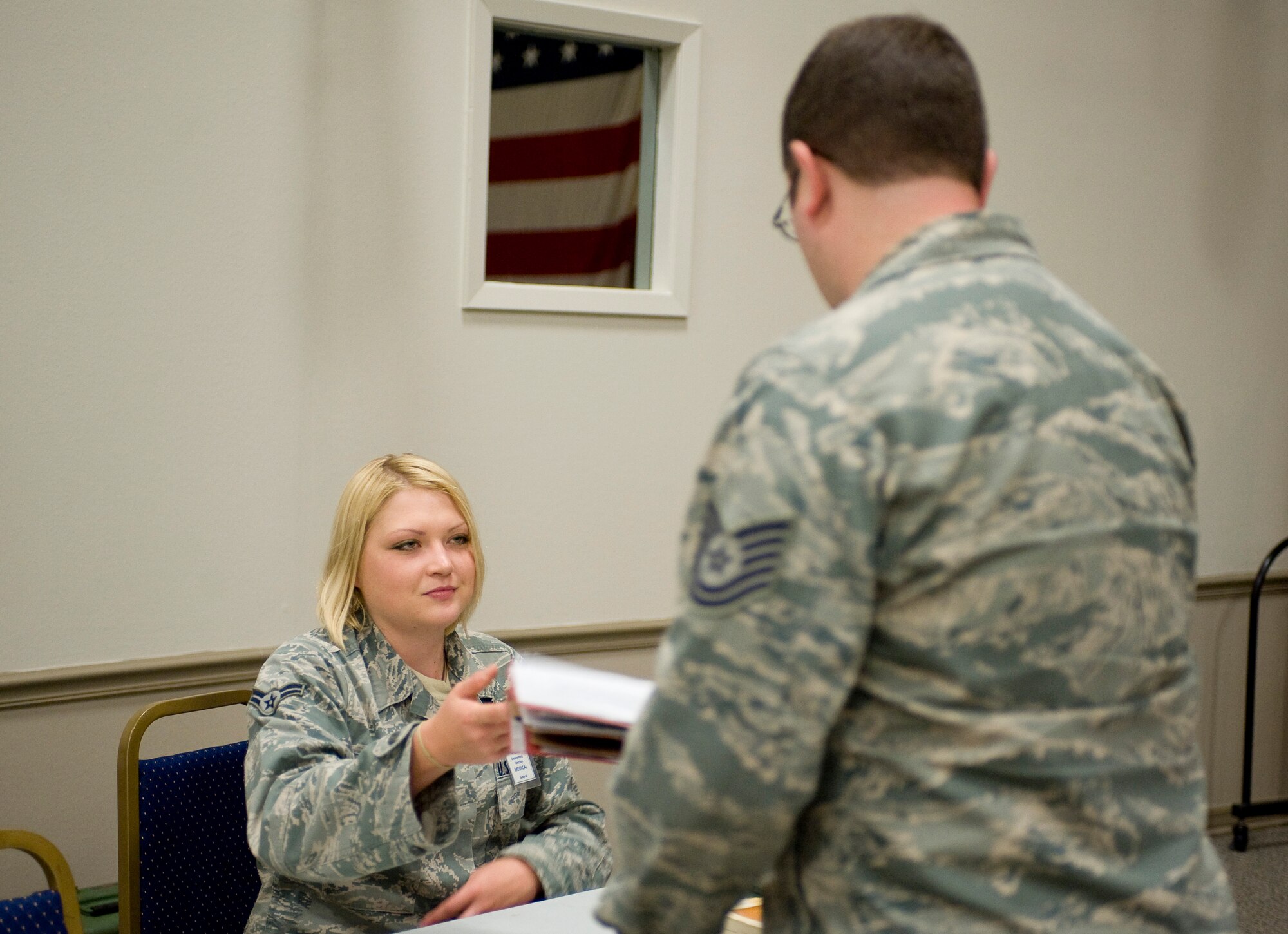 Alycia Provenzo, 2nd Aerospace Medicine Squadron, returns a mobility folder to a simulated deployer during a mobility exercise on Barksdale Air Force Base, La., July 28. Airmen keep up-to-date mobility folders to ensure they are ready to be deployed at a moment's notice. (U.S. Air Force photo/Senior Airman Chad Warren) (RELEASED)