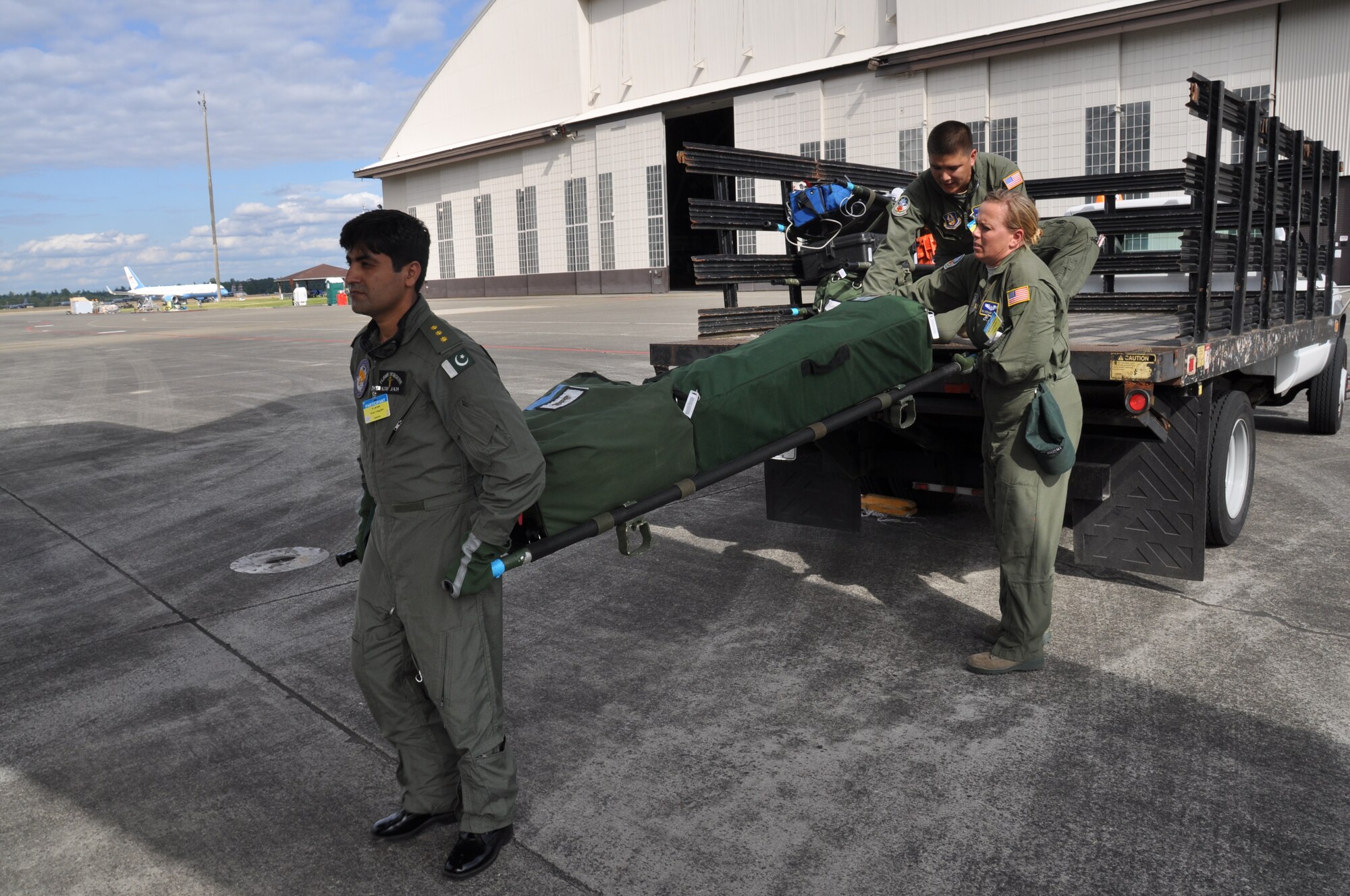 Asif Jah, Pakistan air force flight surgeon, preloads medical gear with members of Team McChord's Aeromedical Evacuation team during the AE competition July 27, 2011. (U.S. Air Force photo/Airman 1st Class Michael Battles)