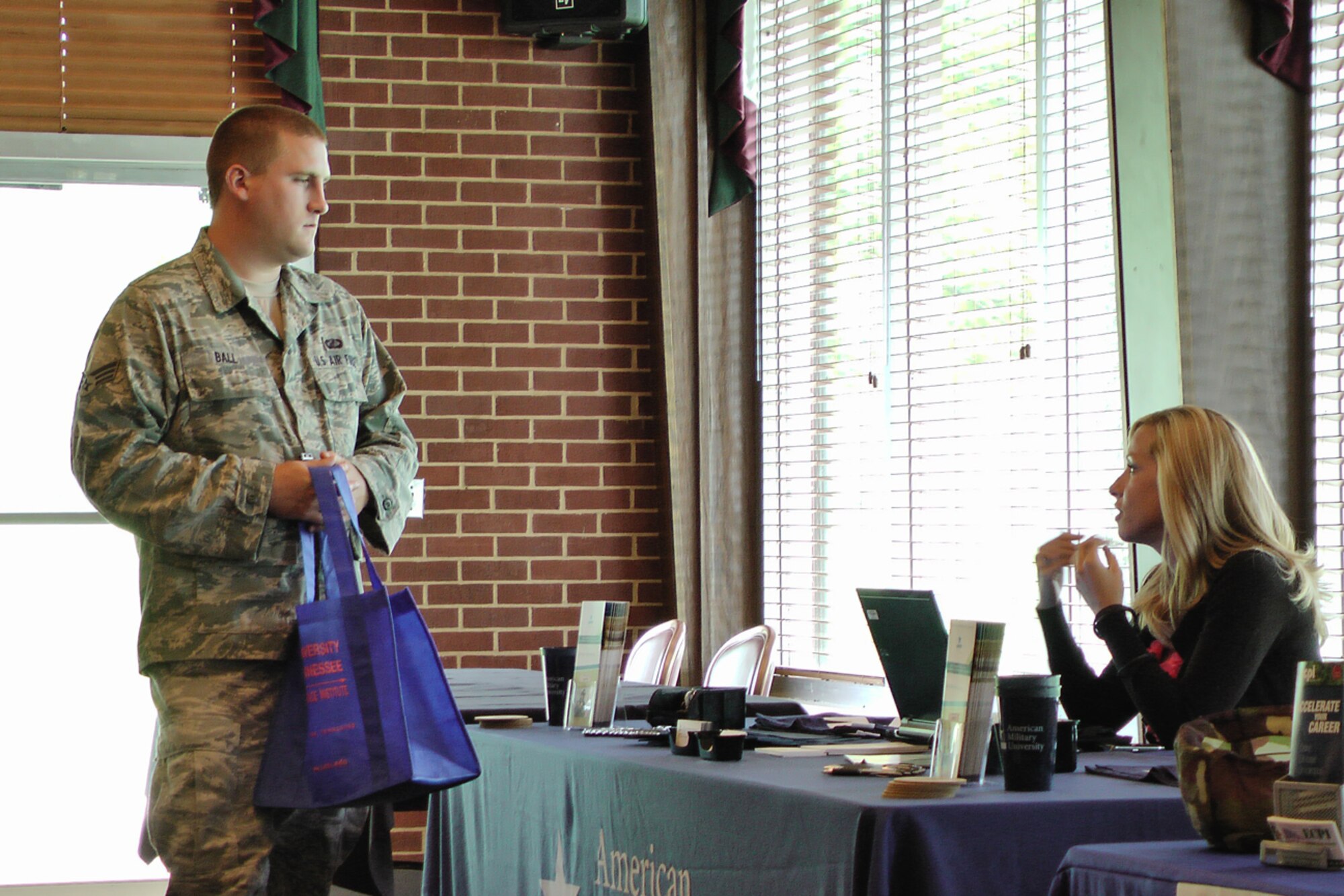 Senior Airman Eric Ball talks with a representative from American Military University (AMU) at the AEDC education fair July 15 at the Arnold Lakeside Center.  Airman Ball is studying online for his Bachelor of Business Administration degree from AMU. (Photo by Patrick Ary)