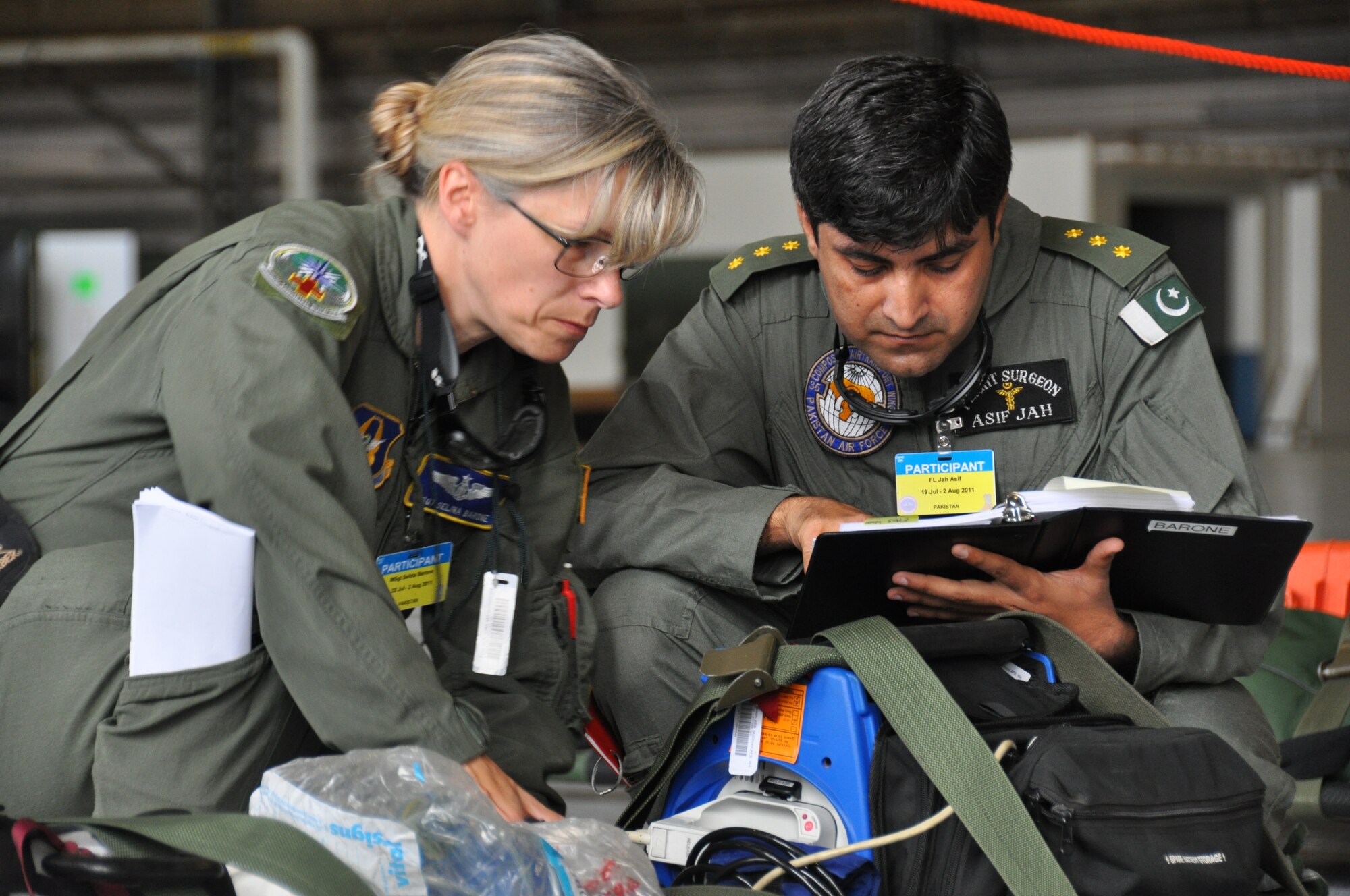 Asif Jah, Pakistan air force flight surgeon, inspects pre-flight gear with a member of Team McChord's Aeromedical Evacuation team during the AE competition July 27, 2011. (U.S. Air Force photo/Airman 1st Class Michael Battles)