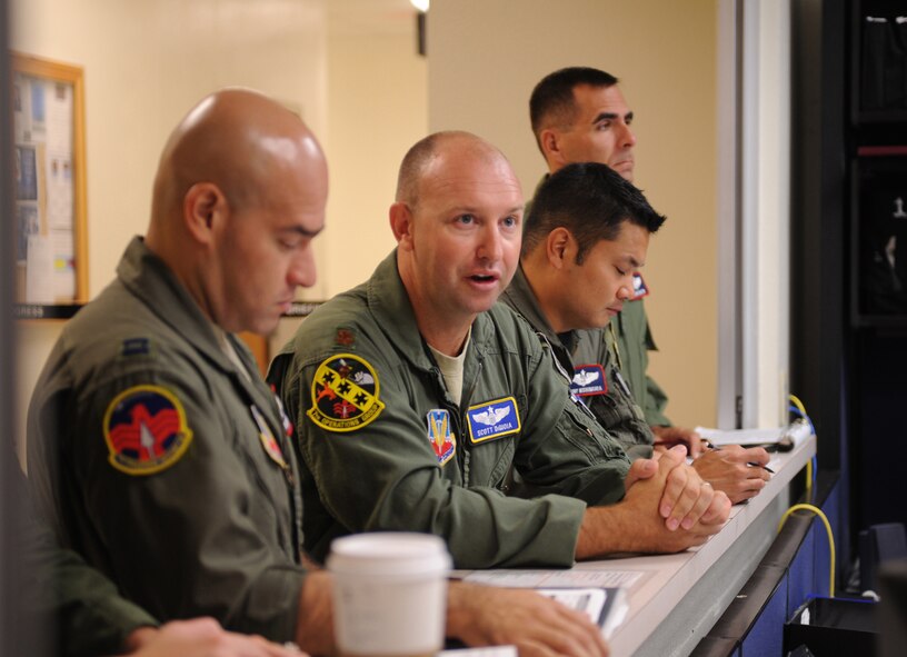 U.S. Air Force Maj. Scott DiGioia, 7th Operations Group, center, verifies pre-flight information July 28, 2011, with the 9th Bomb Squadron operations desk during the 7th Operations Support Squadron's Global Strike Challenge team pre-departure crew brief at Dyess AFB, Texas. The 7th OSS is one of five teams representing Dyess AFB as Dyess tries to bring home the championship a second year in a row.  (U.S. Air Force photo by Tech. Sgt. Darcie L. Ibidapo/Released)