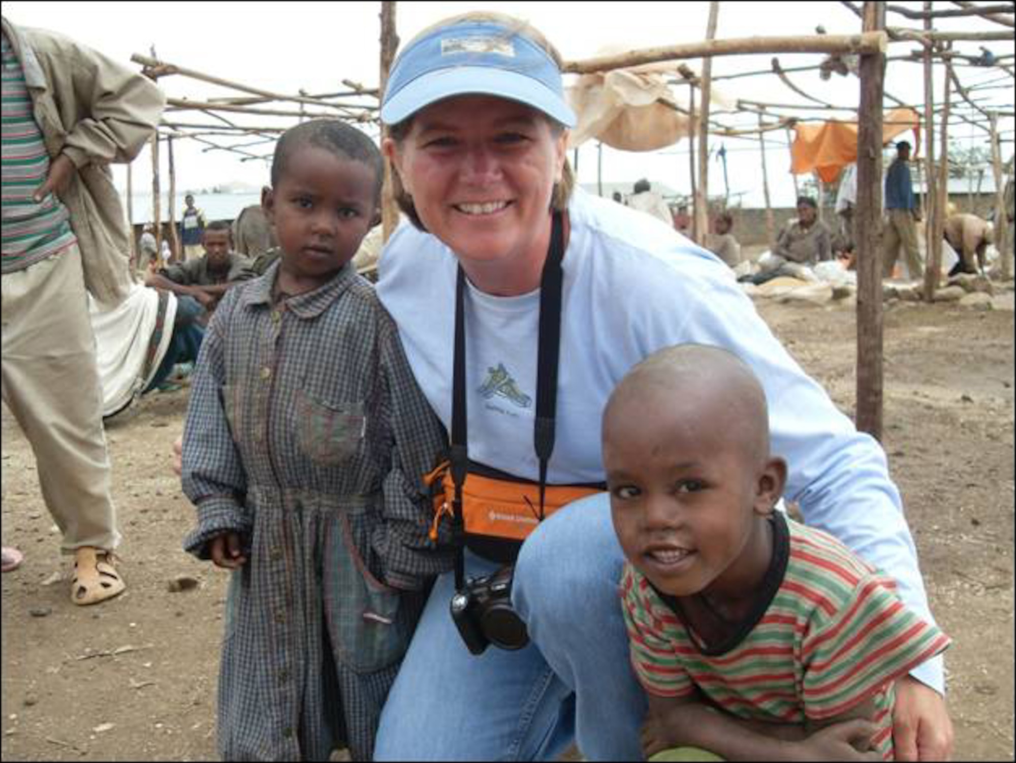 Col. Angela Stout, new 341st Mission Support Group commander, poses with two children during her tour in Ethiopia.  (Courtesy photo)
