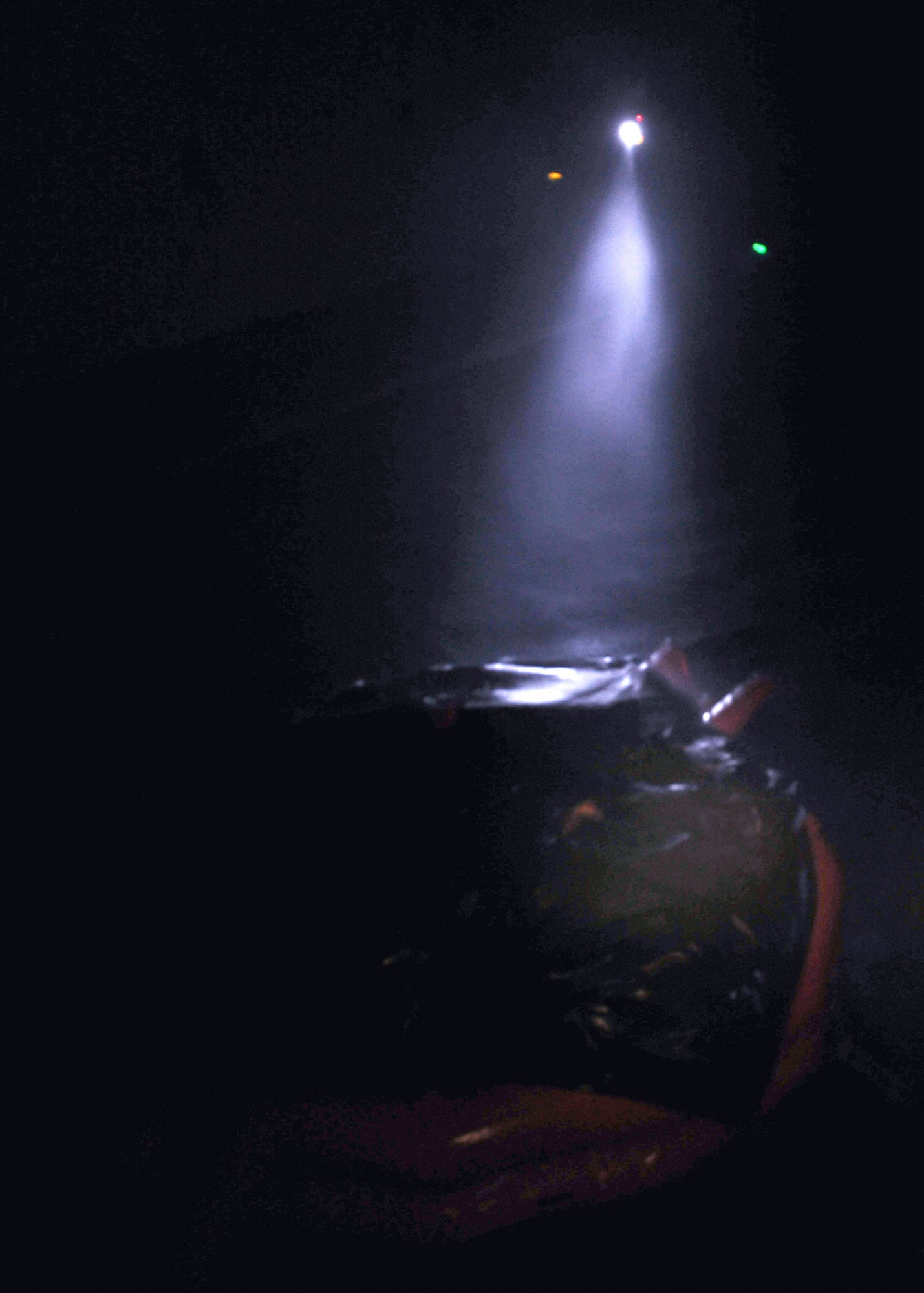 LOWESTOFT COLLEGE, England -- In pitch darkness -- except for a single, intermittent beam of light which shines down on  the 20-man life raft -- severe storm conditions are simulated during water survival training July 14, 2011.  U.S. Air Force members had to jump into the pool -- guided only by the light of a small flashlight -- then brave large waves, rain (from a sprinkler system) and 30-knot winds before clambering into the life raft. (U.S. Air Force photo/Staff Sgt. Tabitha Lee)