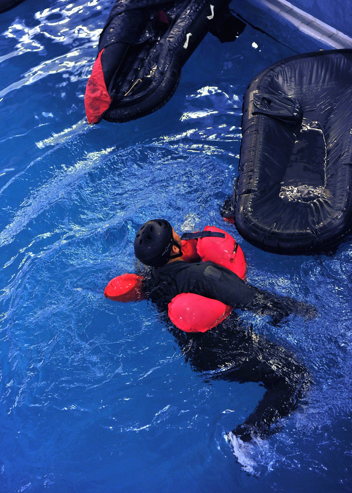 LOWESTOFT COLLEGE, England -- An aircrew member swims over to a single life raft before turning it upright and pulling himself inside July 14, 2011. This is part of the training aircrew have to go through as part of survival, evasion, resistance and escape training. (U.S. Air Force photo/Staff Sgt. Tabitha Lee)