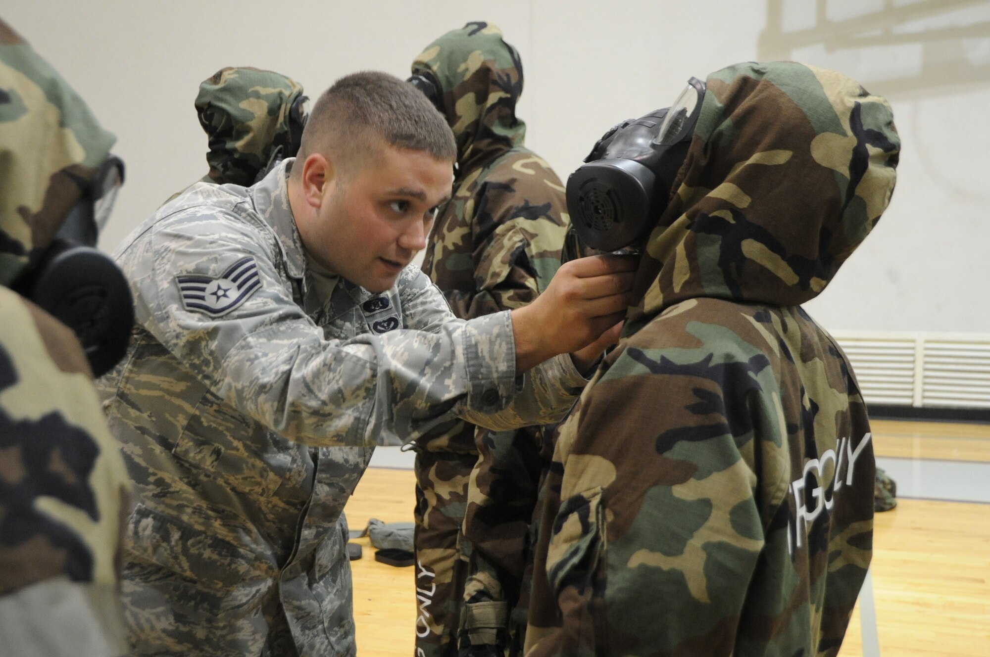 Staff Sgt. Geoffrey Wadsworth, 65th Civil Engineer Squadron, checks to see if the hood draw cord of the chemical protection overgarment is properly fastened during a Warrior Day training exercise held at Lajes Field, Azores, June 6, 2011.  The 65th Air Base Wing conducts training every month in preparation for an Operational Readiness Inspection in September. (Photo by Tech. Sgt. Chyrece Campbell)