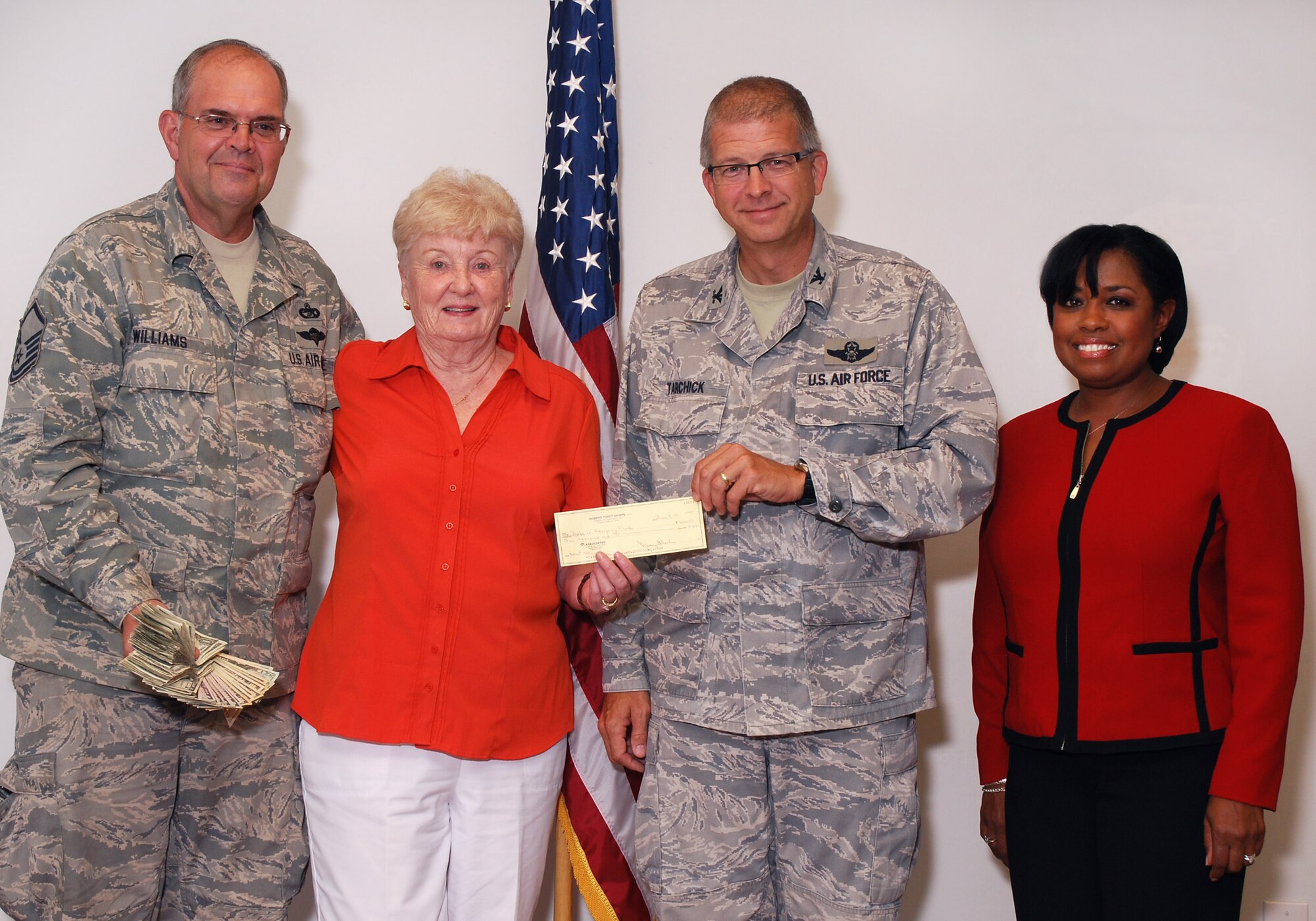 Master Sgt. David "Catfish" Williams holds $631 from the Corn and Sausage Roast while Nancy Black, Dobbins Thrift Store manager, presents a $1,000 check to Col. Tim Tarchick, 94th Airlift Wing commander, and Angela Pedersen, director of the Airmen and Family Readiness, July 28.  The $1631 total for the Airmen and Family Readiness Center came from the 8th annual Corn and Sausage Roast put on recently by the Dobbins Square and Compass Club with the help of many base volunteers and also proceeds from the Dobbins Thrift Store.   (U.S. Air Force photo/ Brad Fallin)
