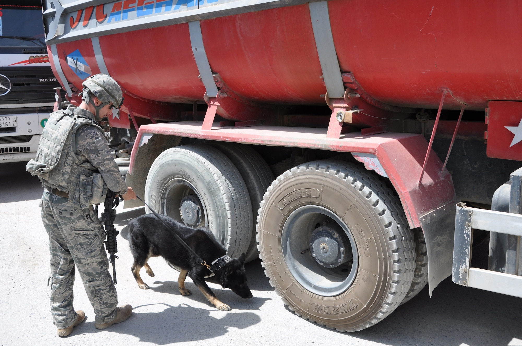 BAGRAM AIRFIELD, Afghanistan -- Senior Airman Brandon Edwards, 455th Expeditionary Security Forces Squadron military working dog handler, and his dog, Waldo, search a vehicle for prohibited items July 26, 2011. The canine’s heightened sense of smell makes it a valuable asset in detecting and preventing illegal drugs and explosives from entering Bagram Airfield. (U.S. Air Force photo/Staff Sgt. John Wright)
