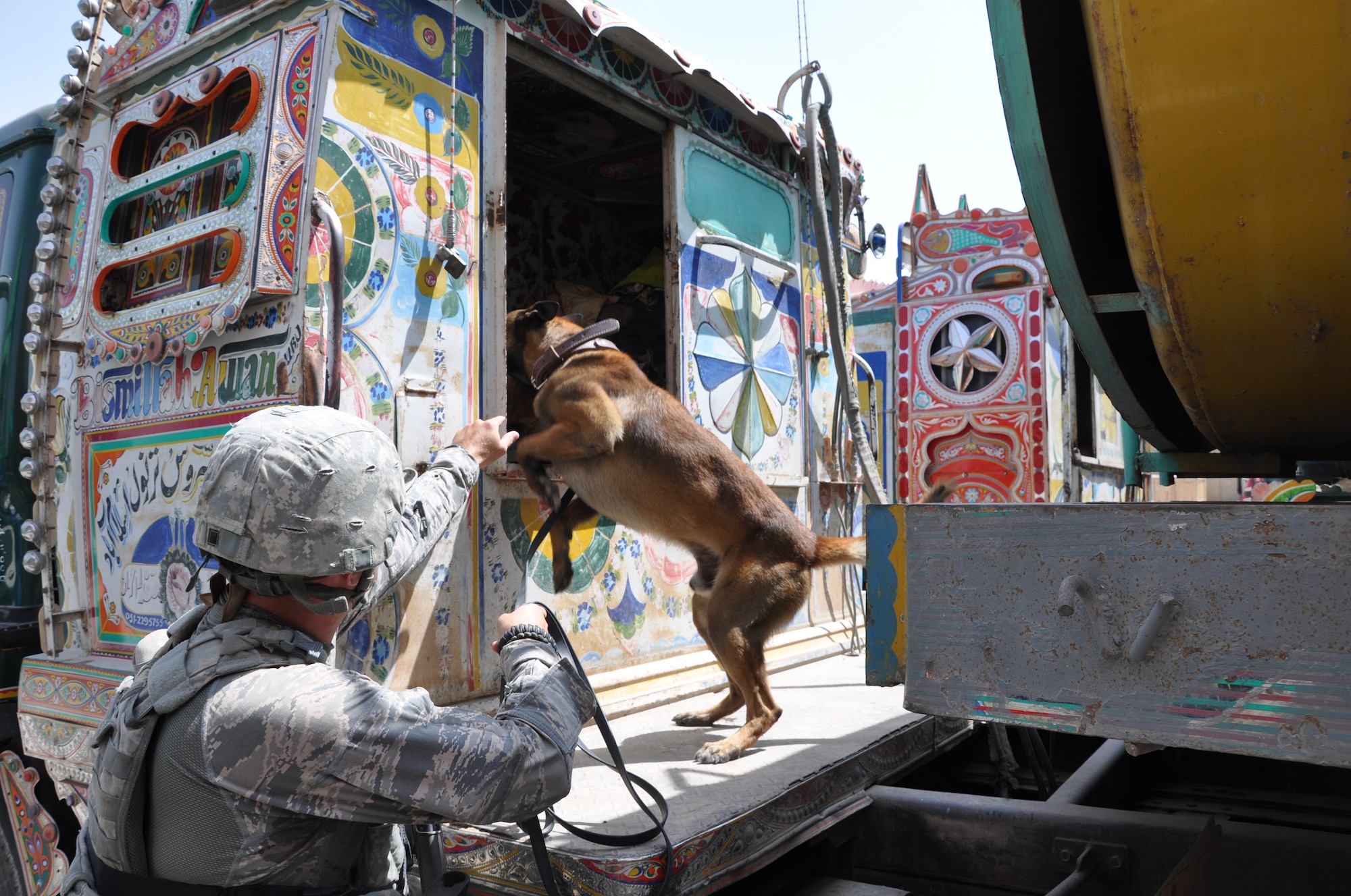 BAGRAM AIRFIELD, Afghanistan – Tech. Sgt. George Shepherd, 455th Expeditionary Security Forces Squadron military working dog handler, directs his dog, Aris, to search inside vehicle for prohibited items July 26, 2011. The canine’s heightened sense of smell makes it a valuable asset in detecting and preventing illegal drugs and explosives from entering Bagram Airfield. (U.S. Air Force photo/Staff Sgt. John Wright)