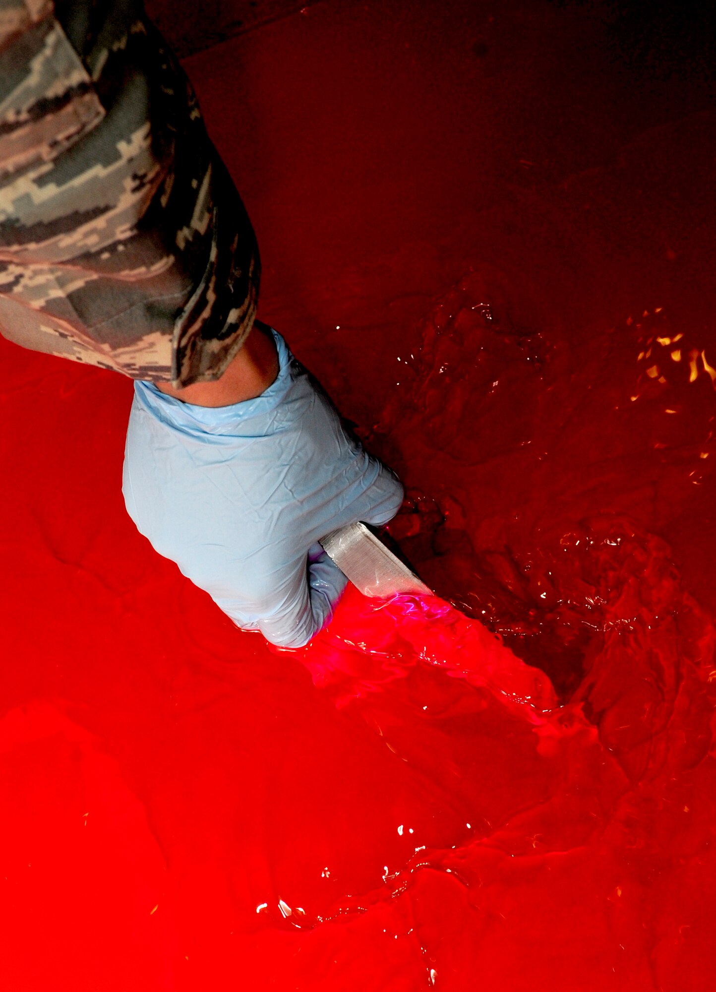 RAF MILDENHALL, England -- A KC-135 Stratotanker jack-mount is dipped into a hydraulic remover during a fluorescent liquid penetrant inspection July 28, 2011. The hydraulic remover is used to eliminate any excess penetrant from the jack-mount that was applied to it earlier in the inspection process leaving only what is left in any possible cracks. (U.S. Air Force photo/Senior Airman Ethan Morgan)