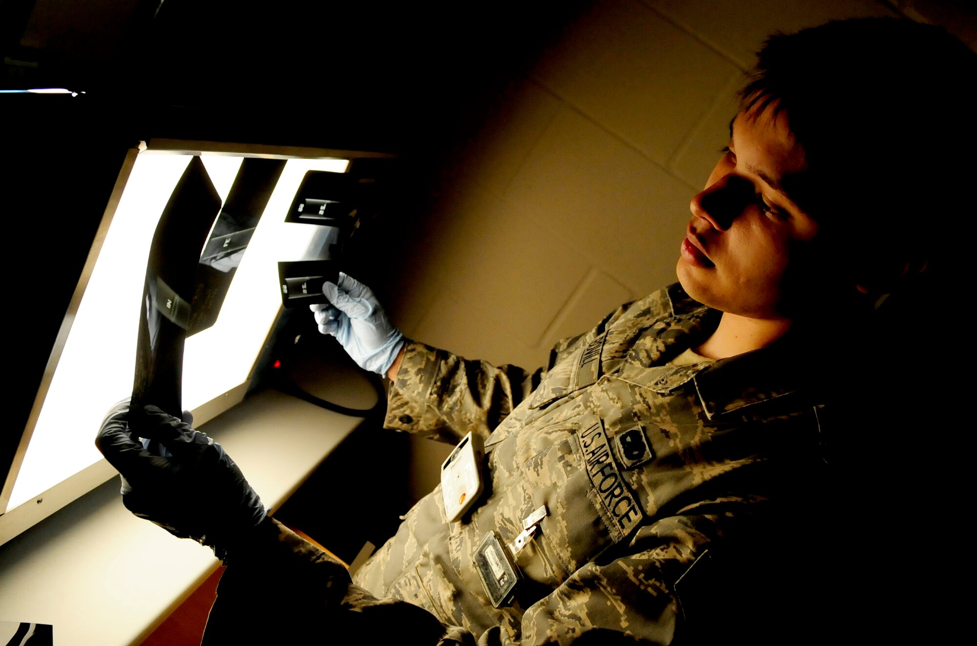 RAF MILDENHALL, England -- Senior Airman Christopher Bovill, 100th Maintenance Squadron Non-Destructive Inspection journeyman, examines X-ray films of weld certification tubes here July 28, 2011. The tubes are inspected to ensure that the qualifying welder is able to create a sufficient seal absent of cracking and gas porosity. (U.S. Air Force photo/Senior Airman Ethan Morgan)