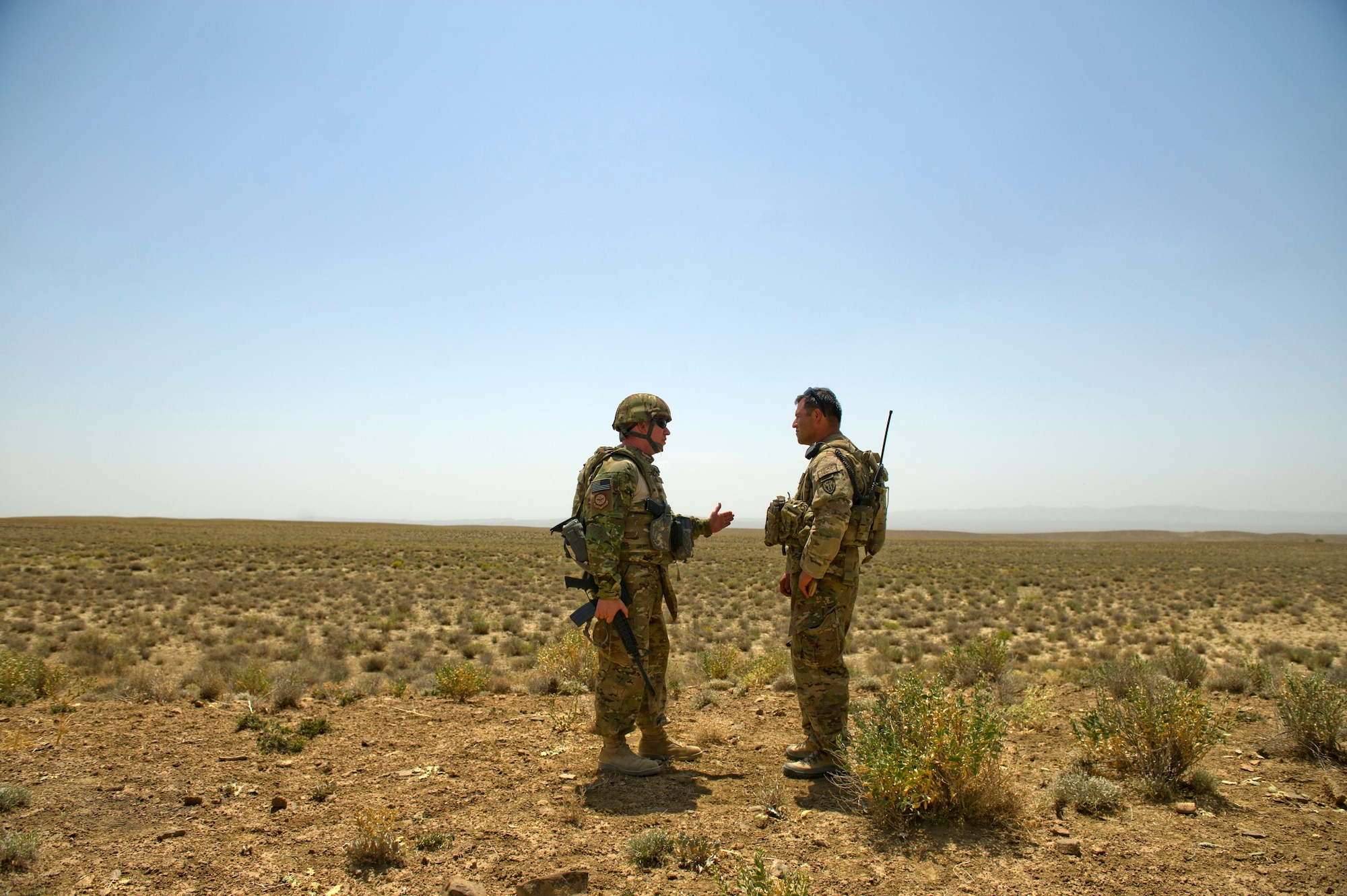 U.S. Air Force Maj, Jason Helton, air mobility liaison officer talks to Sergeant 1st Class Martinez, U.S. Army, 3rd Zone, Afghanistan border police security forces advisement team, about drop zone establishment procedures. The two men are near an ABP outpost in a remote area of southern Afghanistan. Drop zones are important in this area of Afghanistan because they allow for the aerial delivery of critical supplies like food, water and ammunition to troops on the ground. (U.S. Air Force Photo/Master Sgt. Jeffrey Allen)