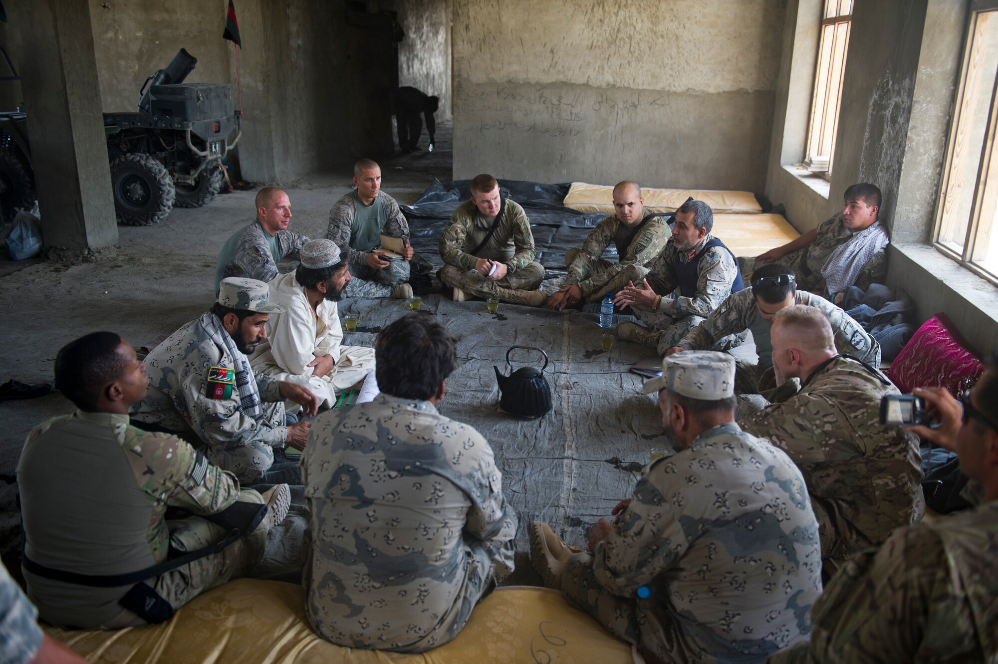Members of the U.S. Army, 3rd Zone, Afghanistan border police security forces advisement team meet with members of the ABP who guard an outpost in southern Afghanistan. The remote location of the outpost makes traditional resupply methods challenging. Air Force air mobility liaison officers work closely with the advisement team to establish drop zones that allow for the air dropping of critical supplies to the troops on the ground. (U.S. Air Force Photo/Master Sgt. Jeffrey Allen)