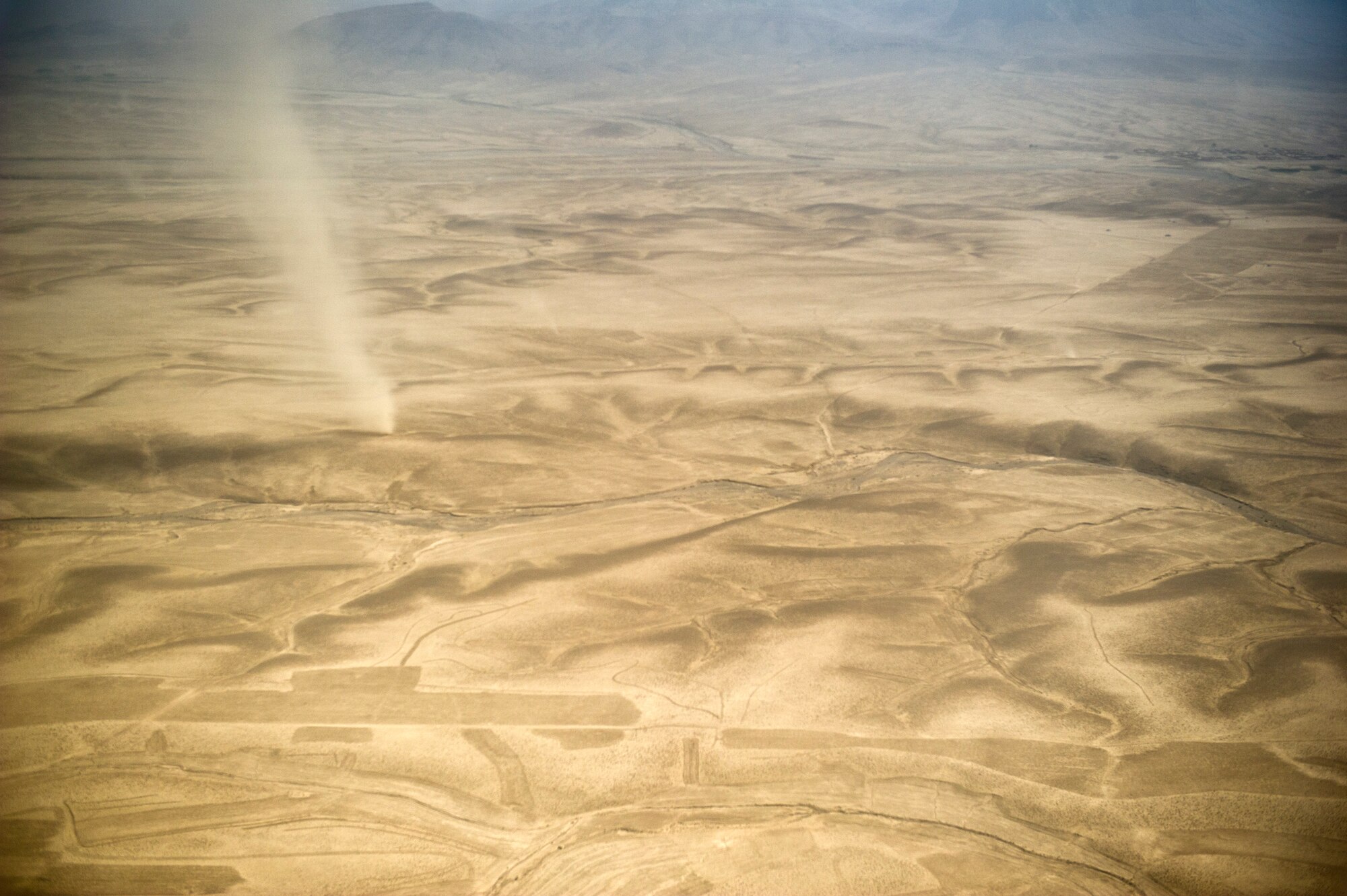 The massive expanse of desert in southern Afghanistan is home to several remote Afghanistan border patrol outposts. A U.S. Army, 3rd Zone, ABP security forces advisement team trains Afghans to patrol and secure their border. The remote location of the outposts poses resupply problems. U.S. Air Force air mobility liaison officers work with the advisement team to establish drop zones used to airdrop critical supplies. (U.S. Air Force Photo/Master Sgt. Jeffrey Allen)