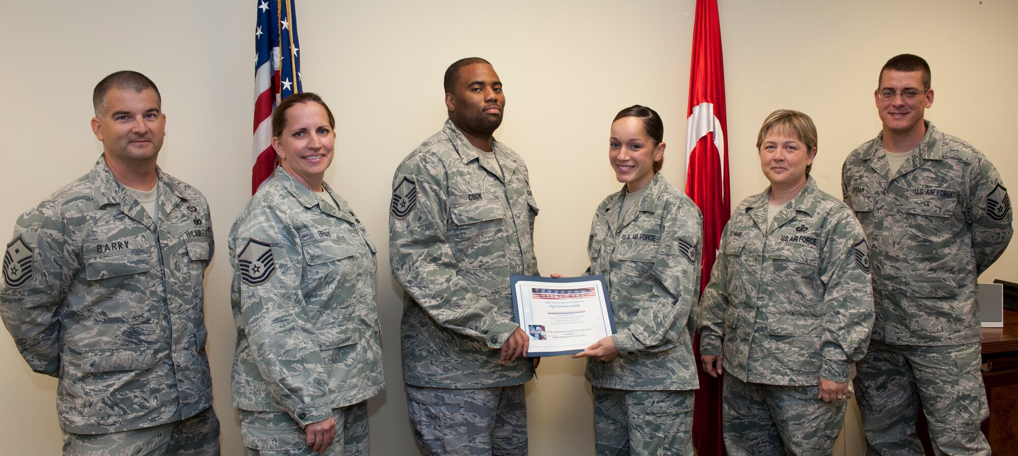 Staff Sgt. Veronica Smith, 39th Comptroller Squadron, receives the Unsung Hero Award from the Incirlik Top 3 July 29, 2011, at Incirlik Air Base, Turkey. The Top 3 presents the Unsung Hero Award monthly to Airmen presenting superior job performance and exceptional leadership. (U.S. Air Force photo by Airman 1st Class Clayton Lenhardt/Released)