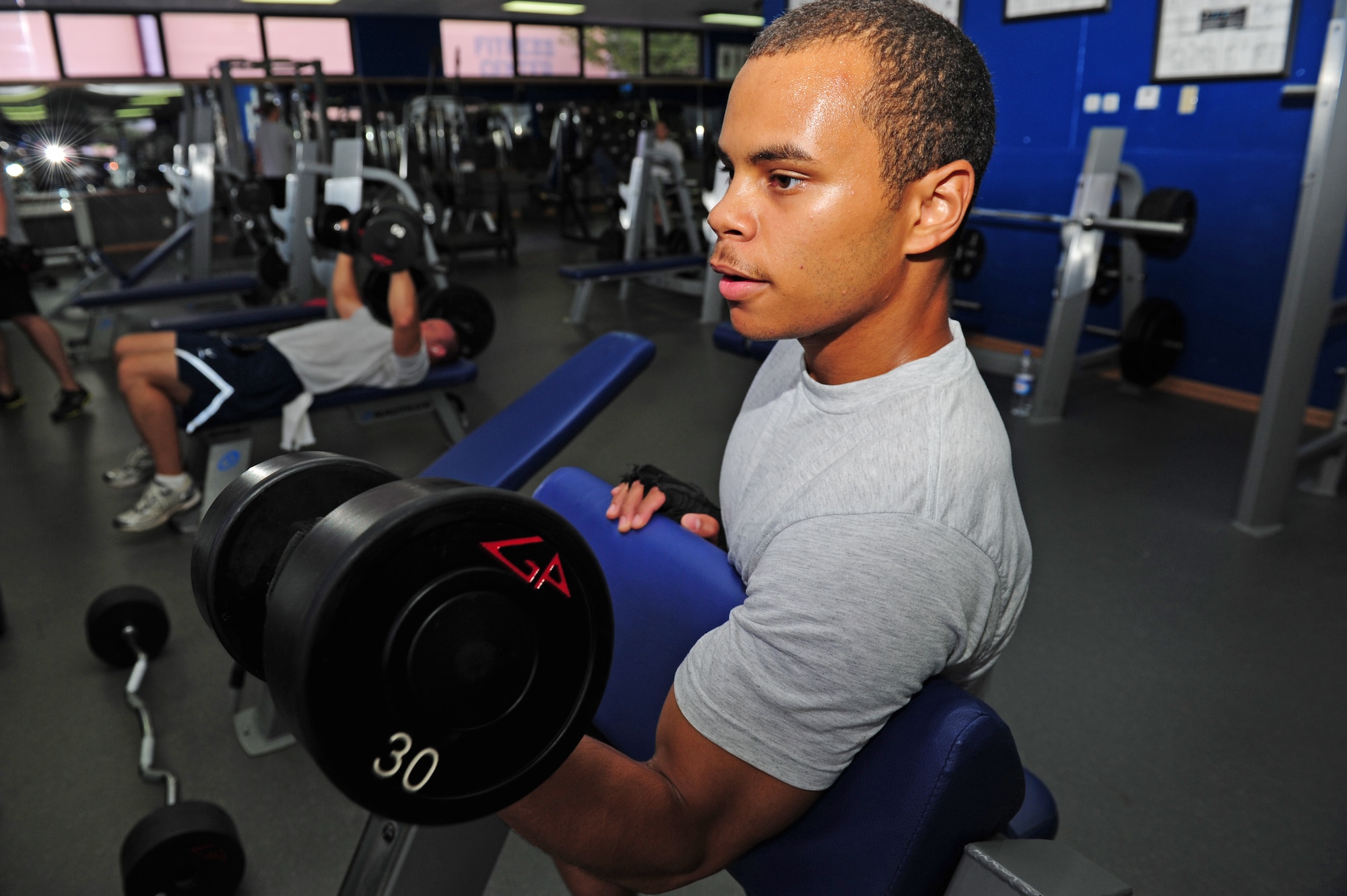 Senior Airman Mike Warren, 39th Logistics Readiness Squadron material management journeyman, demonstrates the proper techniques for the isolated curl July 27, 2011, at Incirlik Air Base, Turkey. Airmen can use a multitude of workout styles to stay safe and physically fit. (U.S. Air Force photo by Senior Airman Anthony Sanchelli/Released)