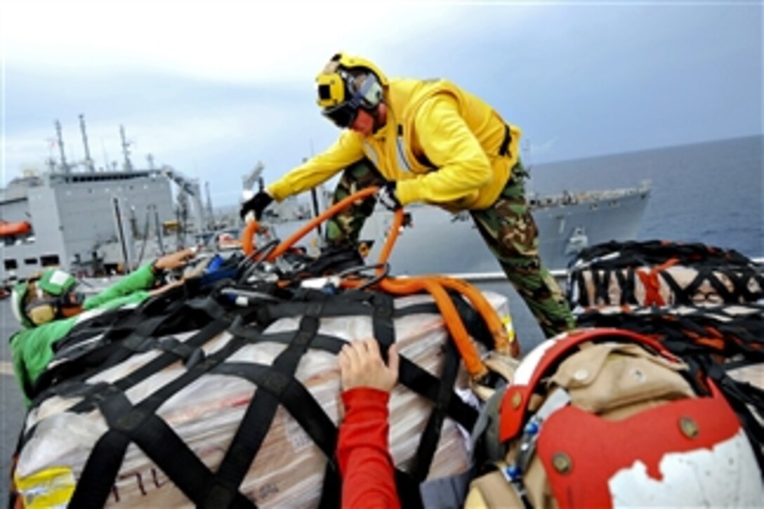 U.S. Navy flight deck personnel assigned to the USNS Comfort unpack cargo during a replenishment mission in the Pacific Ocean on July 26, 2011.  The Comfort is deployed in support of Continuing Promise 2011, a five-month humanitarian assistance mission to the Caribbean, Central and South America.  
