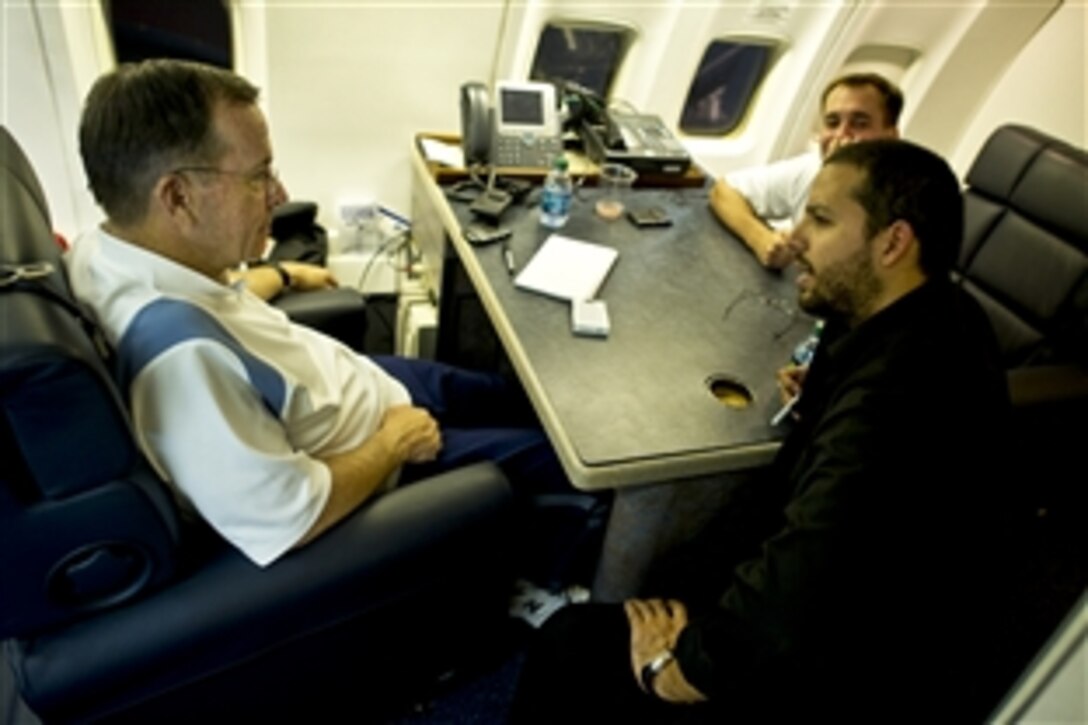 Navy Adm. Mike Mullen, chairman of the Joint Chiefs of Staff, speaks with magician David Blaine  on Mullen's C-32 aircraft, July 28, 2011. Mullen is on a five-day USO tour with Blaine, comedian Jon Stewart and NBA legend Karl Malone to visit troops in Afghanistan and Iraq.