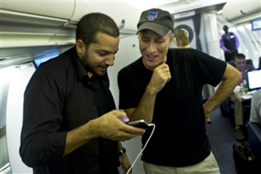 Magician David Blaine talks with comedian Jon Stewart on an aircraft with Navy Adm. Mike Mullen, chairman of the Joint Chiefs of Staff, July 28, 2011, as Mullen begins a five-day USO tour to visit troops in Afghanistan and Iraq.