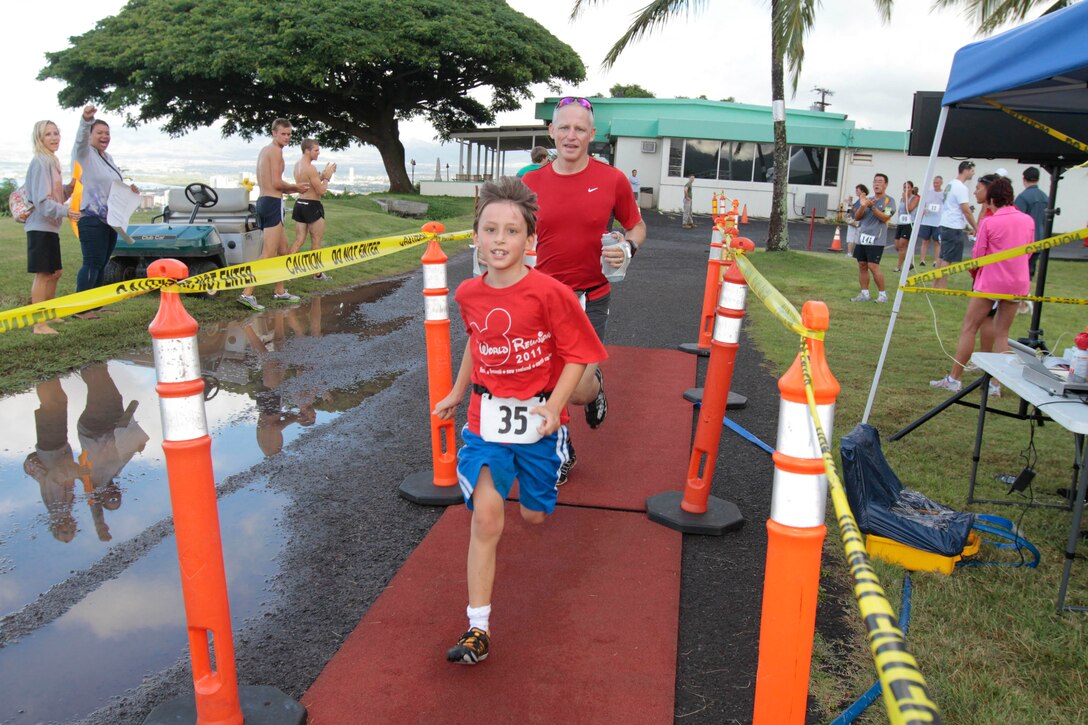Bradley and Lucien Parker cross the finish line together at the Marine Corps Community Services Hawaii Camp H.M. Smith Semper Fit Center's 15th annual 5K Grueler here. The race is held every year to raise funds for the U.S. Marine Corps Forces, Pacific birthday ball.