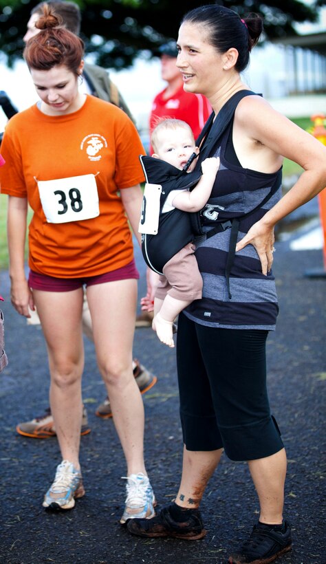 Kathrine J. Harris (right), with her two daughters, Taylor (left) and Jayna Harris, cools off just after crossing the finish line of the Marine Corps Community Services Hawaii Camp H.M. Smith Semper Fit Center’s 5K Grueler. Harris competed in the race with her infant child and older daughter.