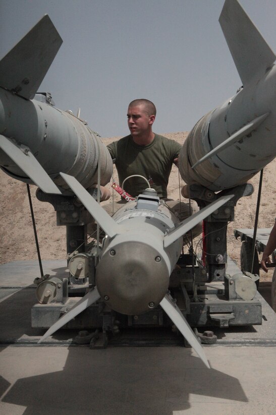 Cpl. Benjamin Corke, a Marine Aviation Logistics Squadron 40 aviation ordnance systems technician and Scottsville, NY, native, inspects a group of GBU-54 bombs at Kandahar Airfield, Afghanistan, July 30.