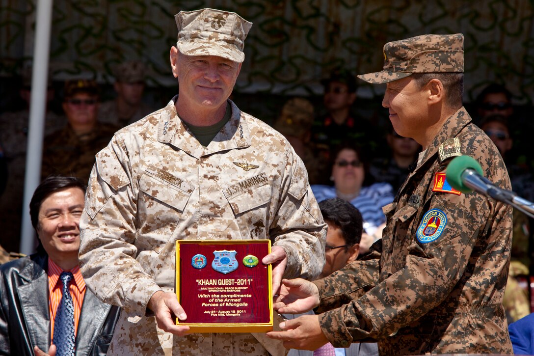 Brig. Gen. Bg. Badombazar, operations chief, chief of general staff, Mongolian Armed Forces (right), presents a memento to Lt. Gen. Kenneth J. Glueck Jr., commanding general, III Marine Expeditionary Force and commander. Marine Corps Bases Japan, during the opening ceremony of Exercise Khaan Quest 2011 near Ulaanbaatar, Mongolia, July 31. Khaan Quest is a training exercise designed to strengthen the capabilities of U.S., Mongolian and other nations’ forces in international peace support operations worldwide.