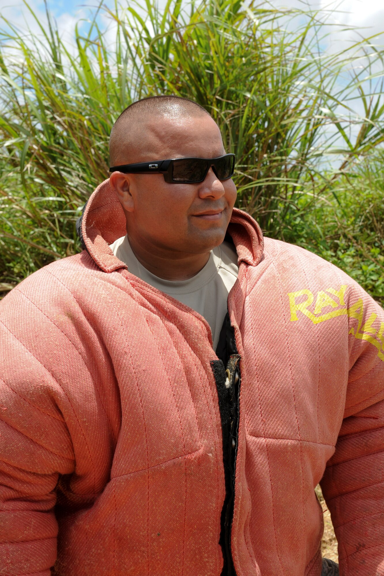 Tech. Sgt. Adolph Rodriguez Jr., 18th Security Forces Squadron trainer, wears a 10-pound bite suit and hides for training at Area 1 July 27. Rodriguez posed as a decoy for a Military Working Dog to locate as the suspect during a scout. (U.S. Air Force photo/Airman 1st Class Brooke P. Beers)