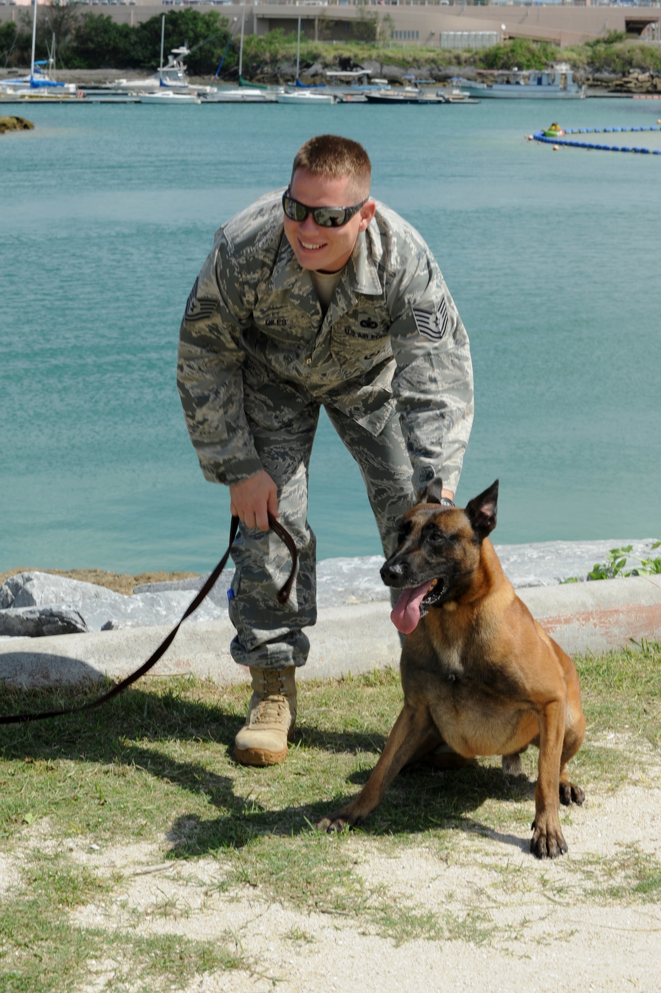 Tech. Sgt. Joshua Giles, 18th Security Forces Squadron kennel master, holds back Military Working Dog Tico during training at the Kadena Marina July 27. Handlers must train regularly to maintain their certifications and also keep the dogs up to speed. (U.S. Air Force photo/Airman 1st Class Brooke P. Beers)