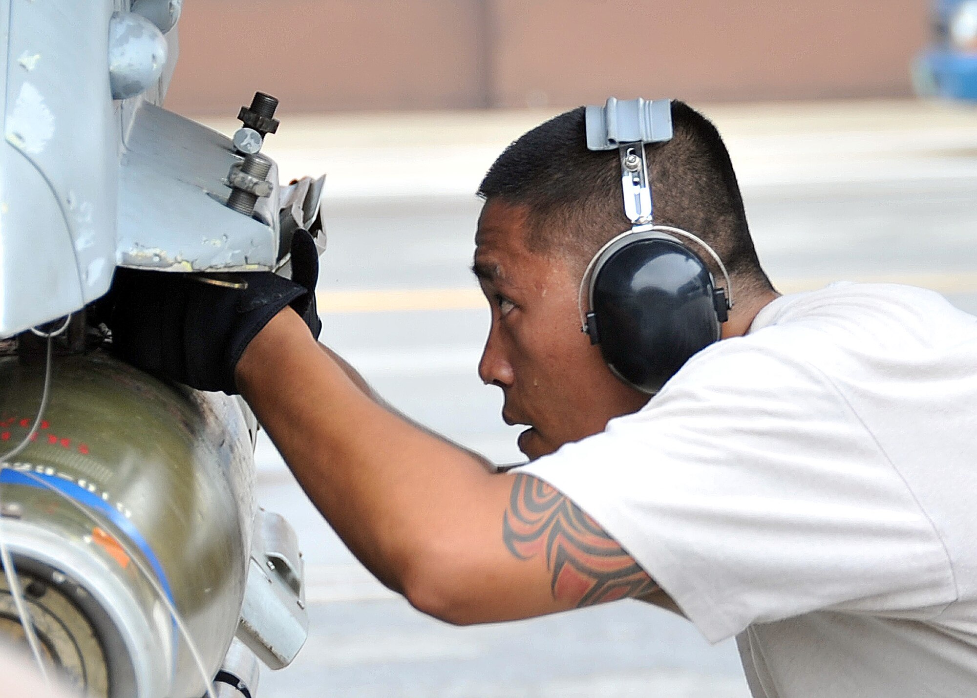 Staff Sgt. Ralph Mendoza, 36th Aircraft Maintenance Unit weapons load crew team chief, tightens bolts during the 51 Fighter Wing load crew competition July. 22. Sergeant Mendoza’s team was comprised of two Senior Airman Brendon Howbert and Lance Weyenth. (U.S. Air Force Photos by/ Senior Airman Adam Grant)