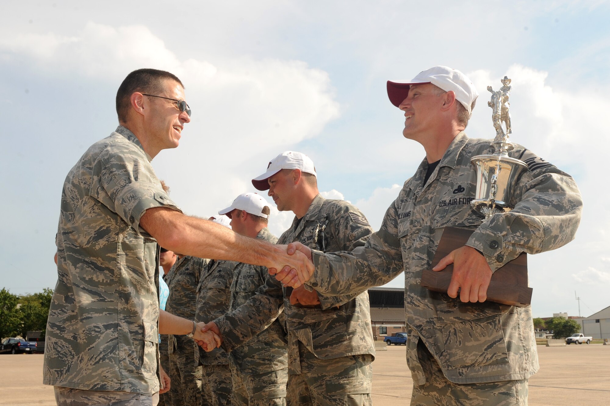 Master Sgt. Wayne McWilliams (right), 314th Airlift Wing C-130J RODEO team chief, is congratulated by Col. Steven Weld, 314th Maintenance Group commander, on July 30, 2011, at Little Rock Air Force Base, Ark.  McWilliams holds one of six trophies the team won during the Air Mobility RODEO 2011 held at McChord Field at Joint Base Lewis-McChord, Wash., from July 24 - 29. (U.S. Air Force photo by Tech. Sgt. Chad Chisholm)