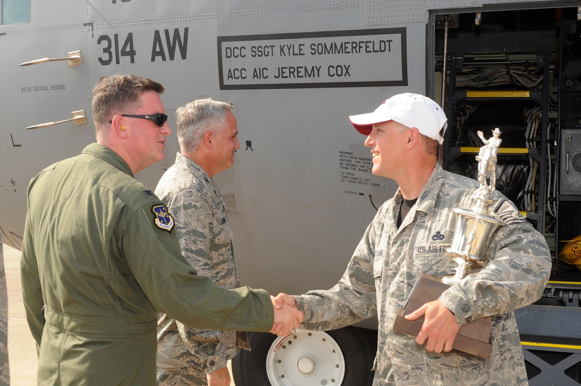 Master Sgt. Wayne McWilliams (right), 314th Airlift Wing C-130J RODEO team chief, is congratulated by Col. Thomas Crimmins, 19th Airlift Wing vice commander, on July 30, 2011, at Little Rock Air Force Base, Ark.  McWilliams holds one of six trophies the team won during the Air Mobility RODEO 2011 held at McChord Field at Joint Base Lewis-McChord, Wash., from July 24 - 29. (U.S. Air Force photo by Tech. Sgt. Chad Chisholm)