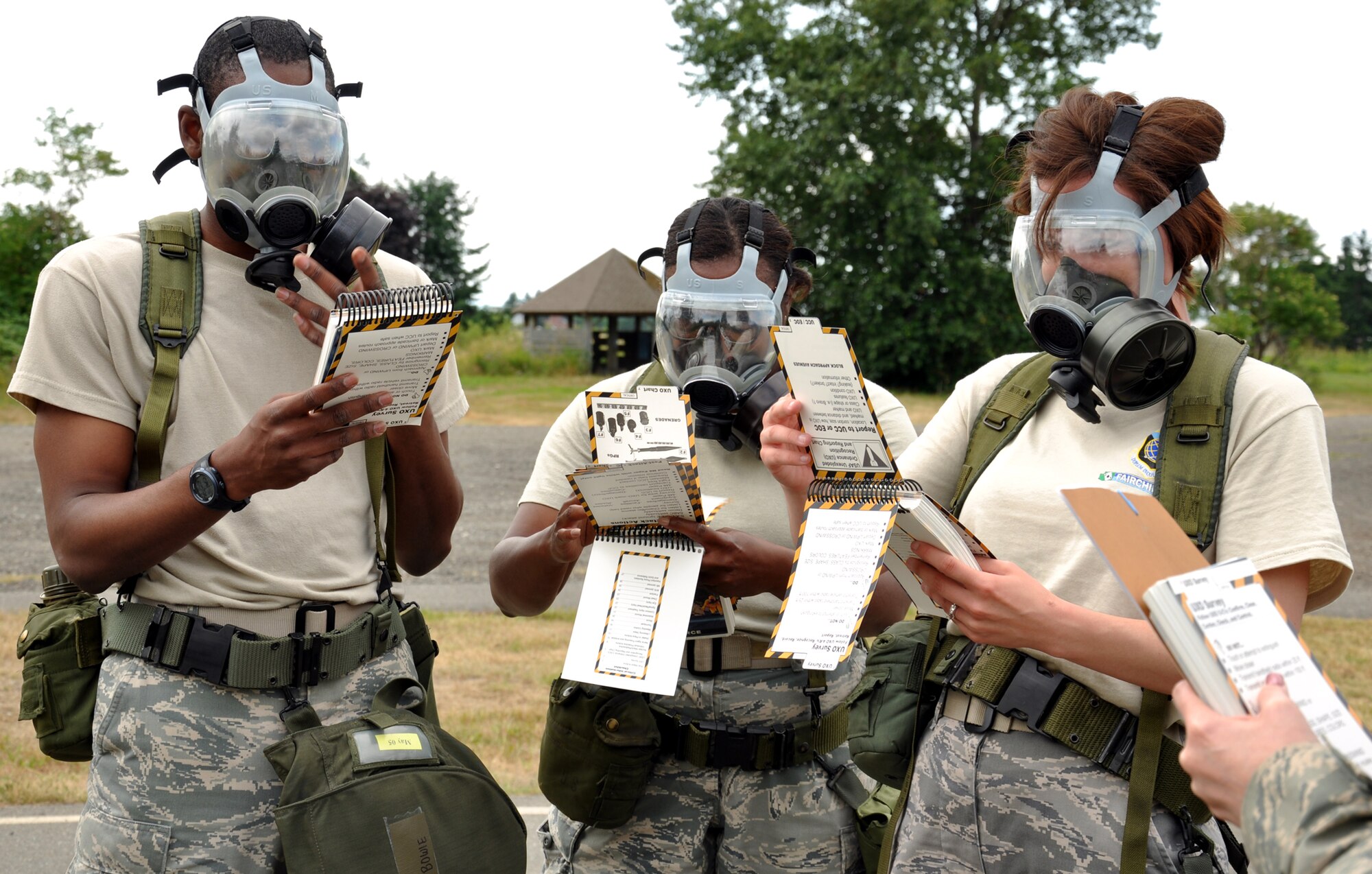 From left, Senior Airman Lyndell Bowie, Tech. Sgt. Adrienne Johnson and Staff Sgt. Christie Bates are at the halfway point of their run and are answering a question for the umpires using their Airman's Manual while wearing their gas masks as part of the challenge course July 26 at Joint Base Lewis-McChord, Wash. This was the first year finance participated in Air Mobility Rodeo. Their rigorous schedule included 12 hours each competition day of finance scenarios. (U.S. Air Force Photo/Tech. Sgt. Jennifer Buzanowski)